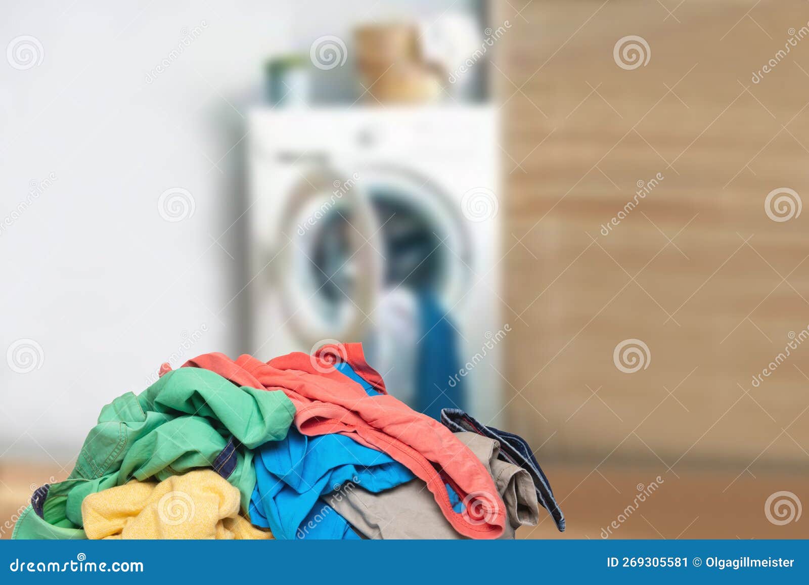 stack or pile of colorful dirty clothes on table ready for the laundry in front of abstract blurred bath background with copy