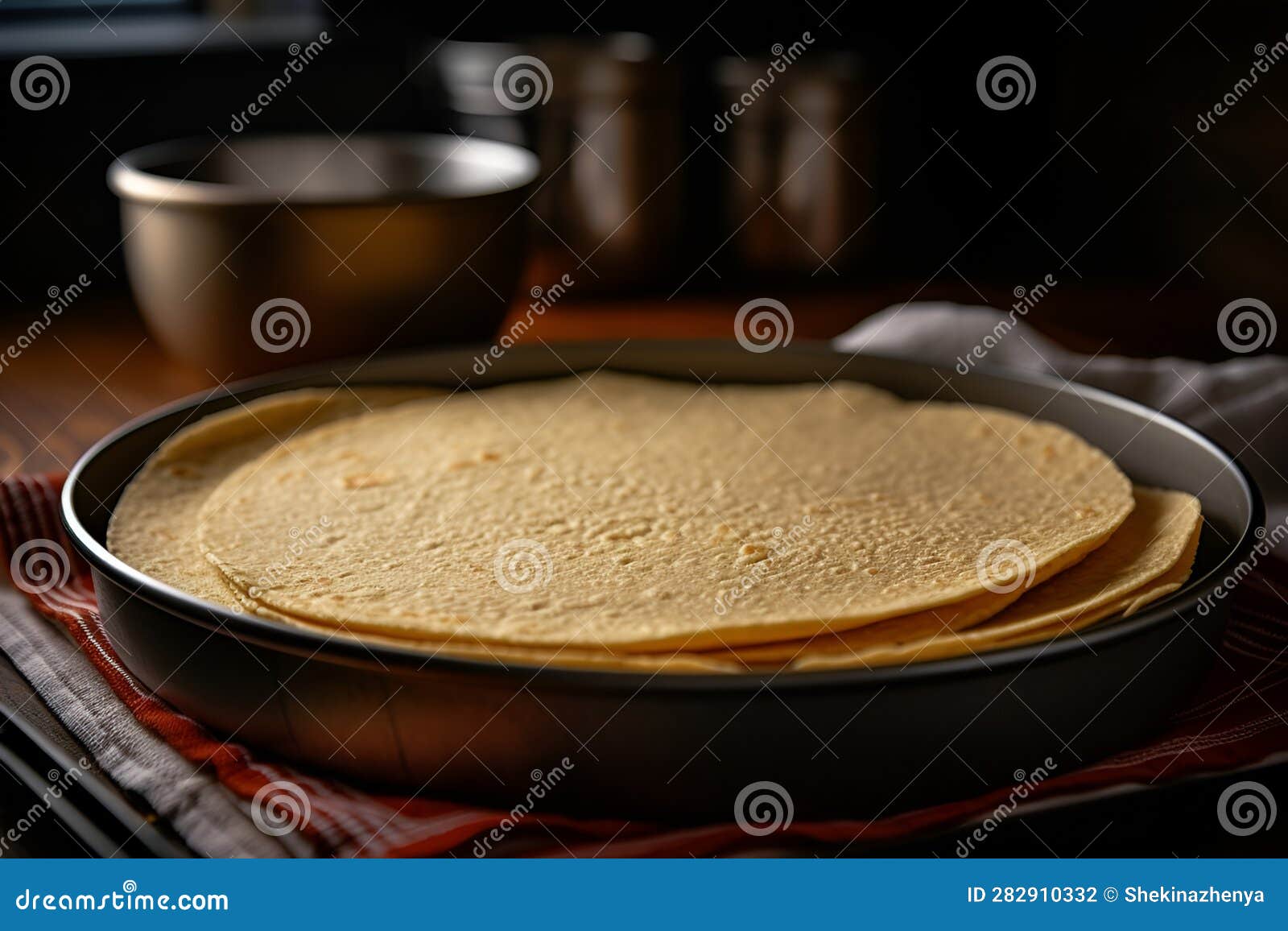 A Stack of Tortillas in a Cast Iron Pan on a Wooden Table. Traditional