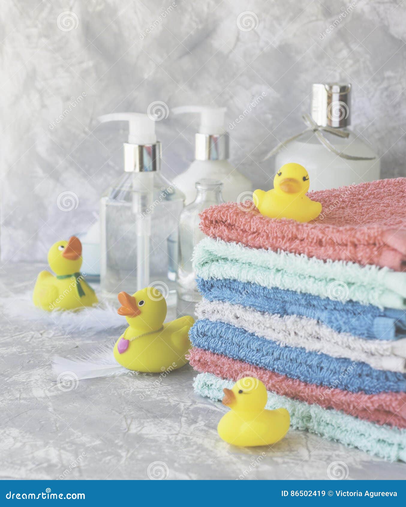 Stack of Towels with Yellow Rubber Bath Ducks on White Marble