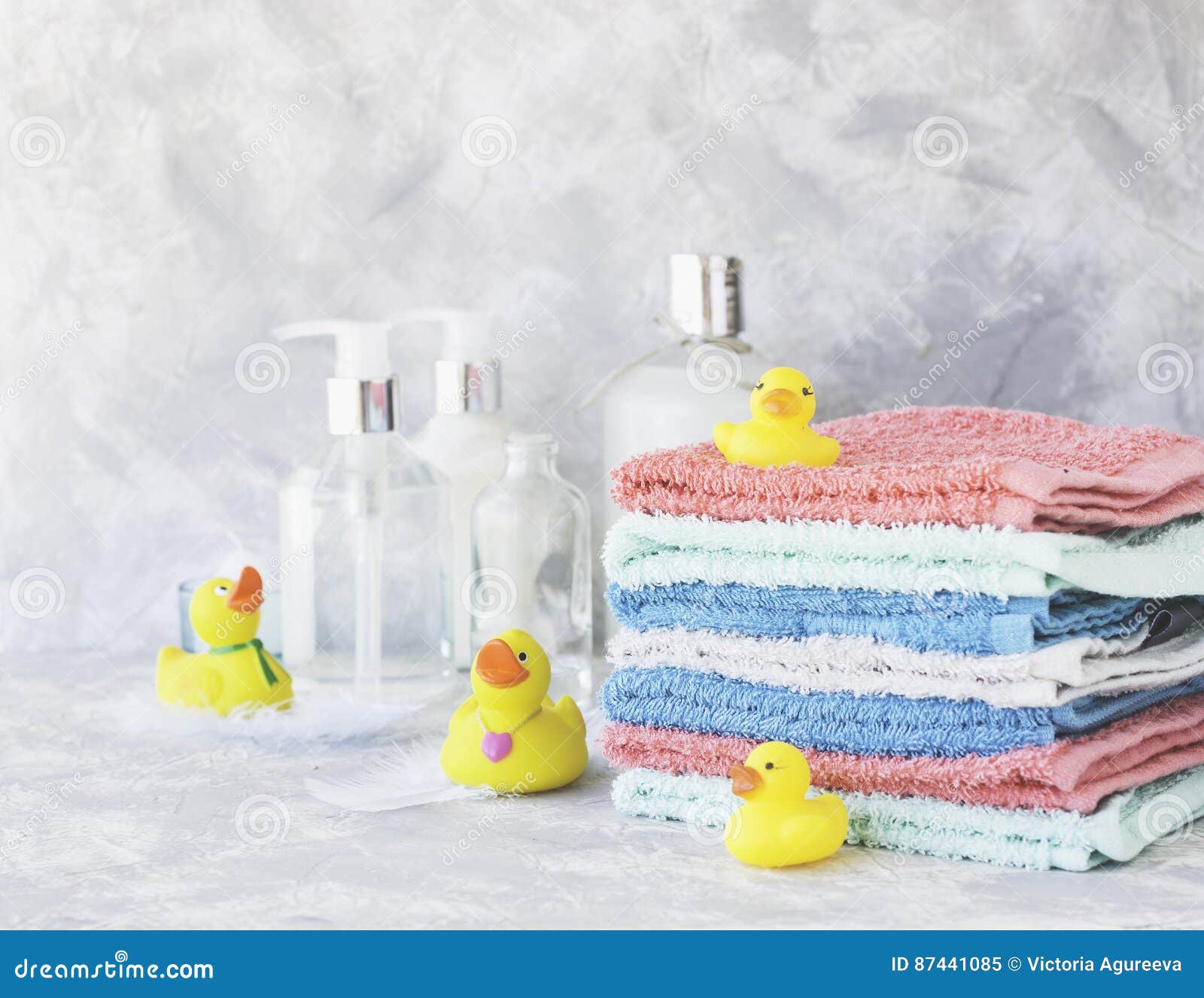 Stack of Towels with Yellow Rubber Bath Ducks on White Marble