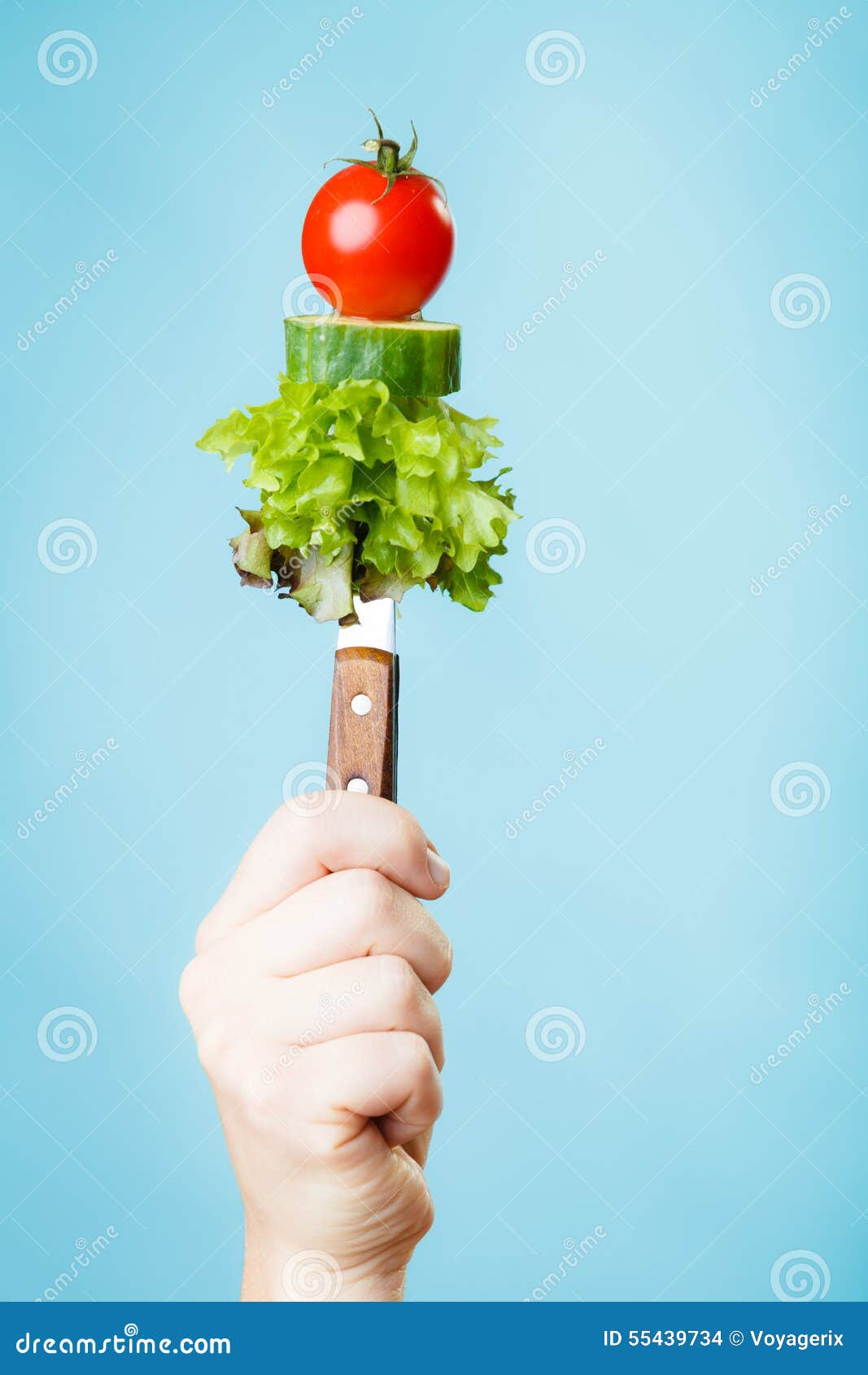 stack of vegetales on knife in hand