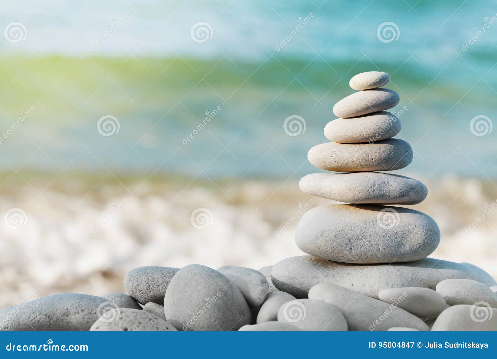 stack of white pebbles stone against blue sea background for spa, balance, meditation and zen theme.