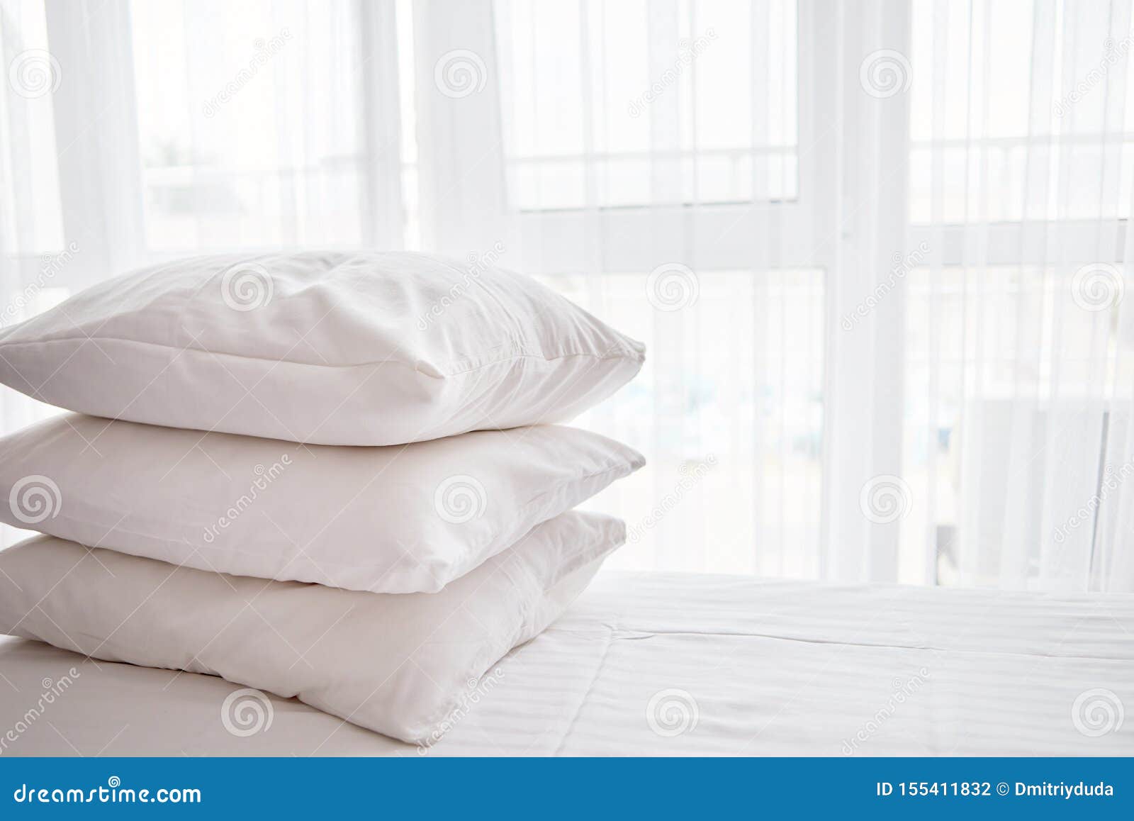 Stack of White Soft Pillows on Comfortable Bed Sheet with Window on
