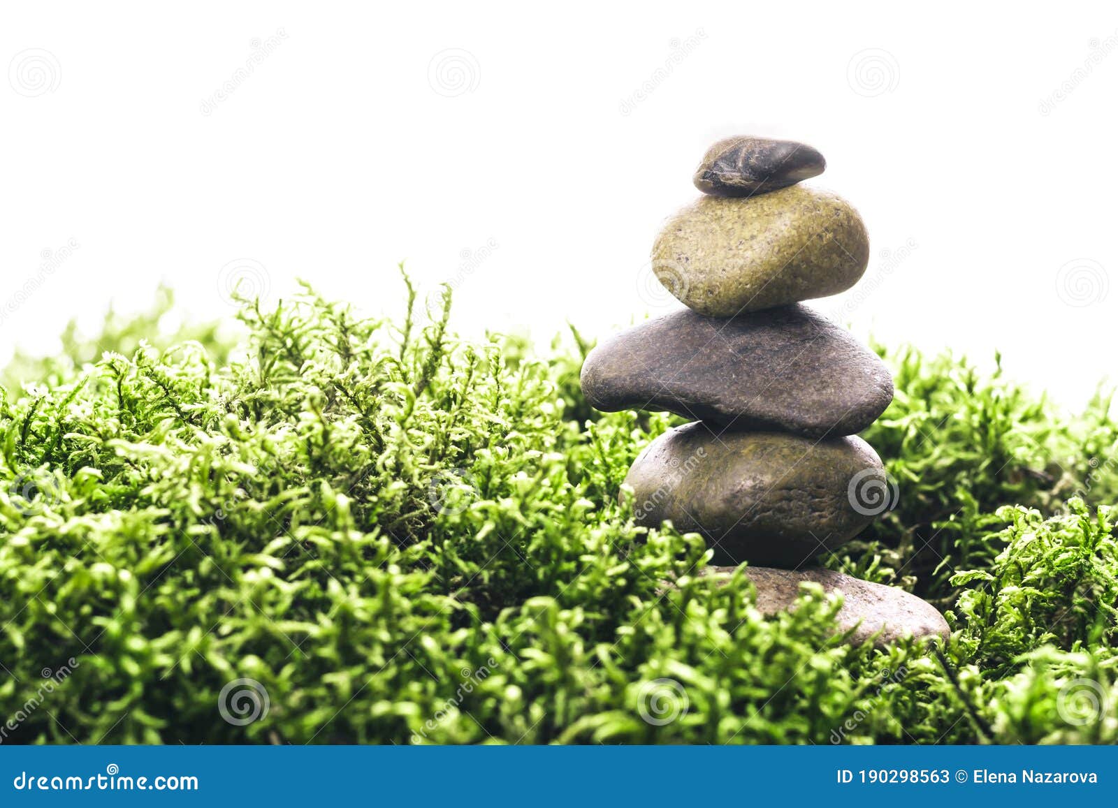 Stack of Zen Stones in Green Moss on White Background. Natural Backdrop
