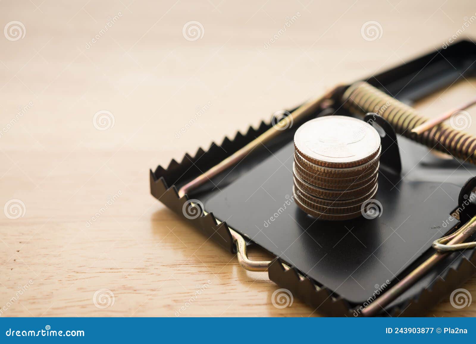 Stacked Coins in a Rat Trap on Wooden Background. Online Internet