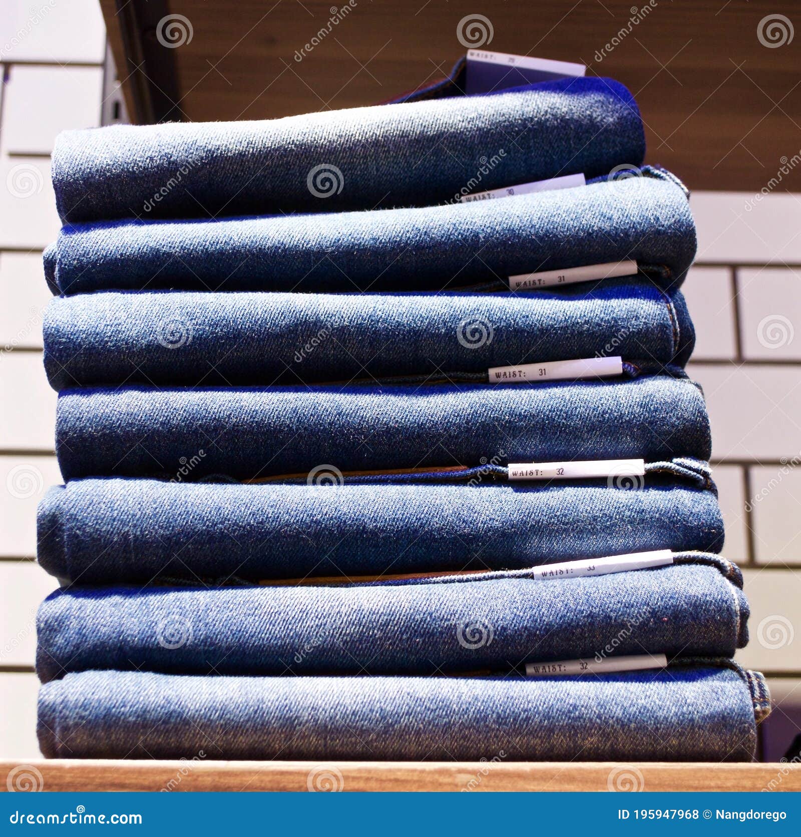 Stacked of Folded Jeans at Store on Wooden Shelf Stock Photo - Image of ...