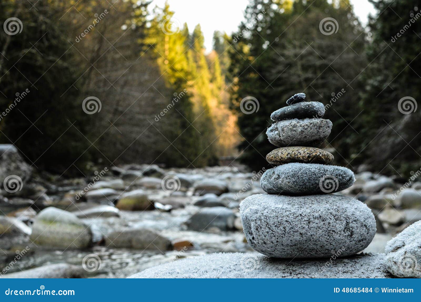 zen stones stacked on river scene