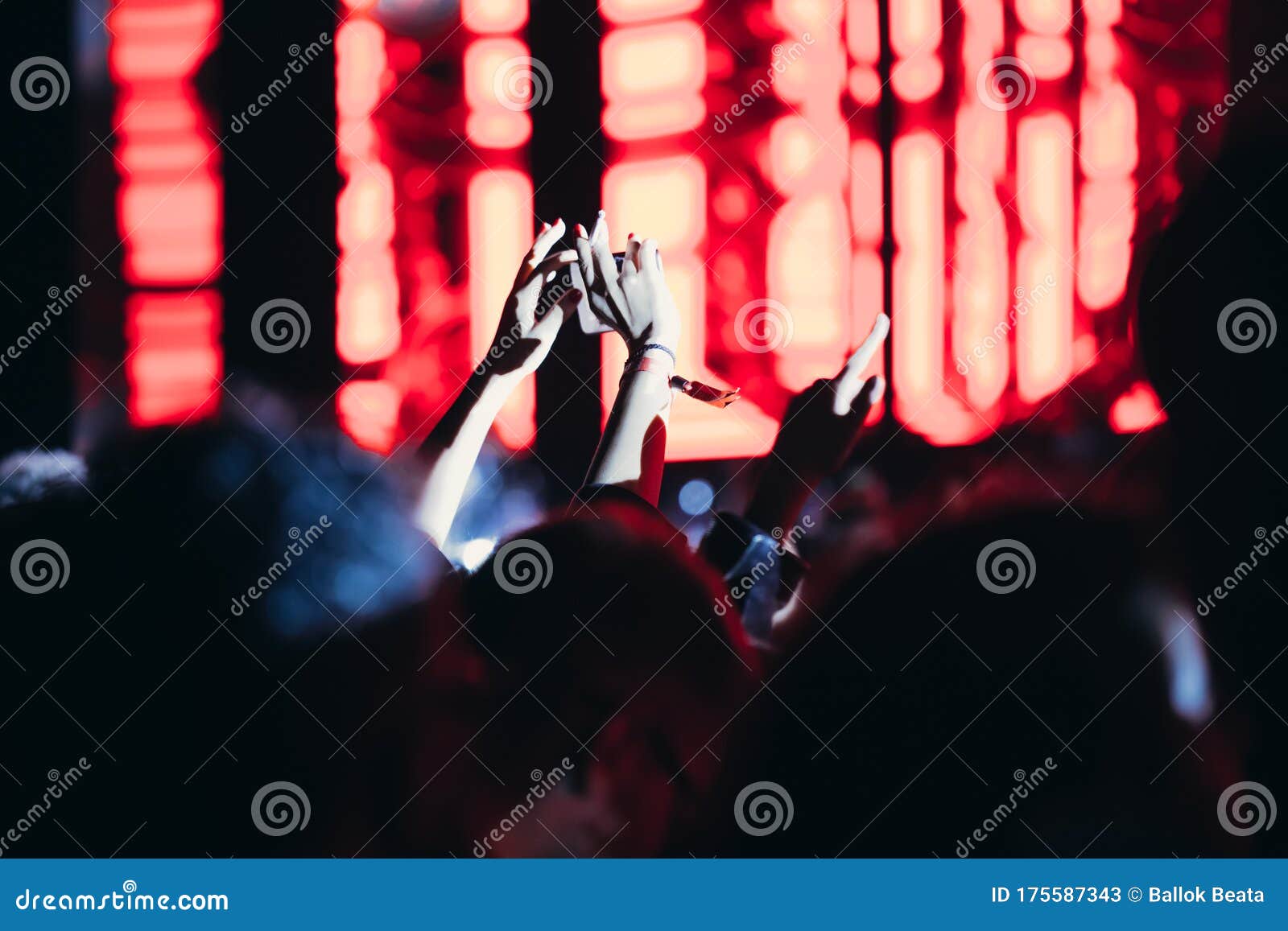 stage lights and crowd of audience with hands raised at a music festival. fans enjoying the party vibes