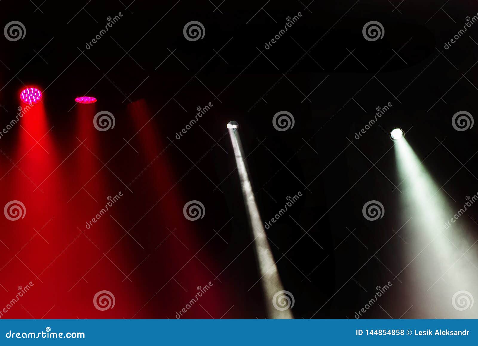 stage lights. several projectors in the dark. multi-colored light beams from the stage spotlights on the stage in the smoke at the