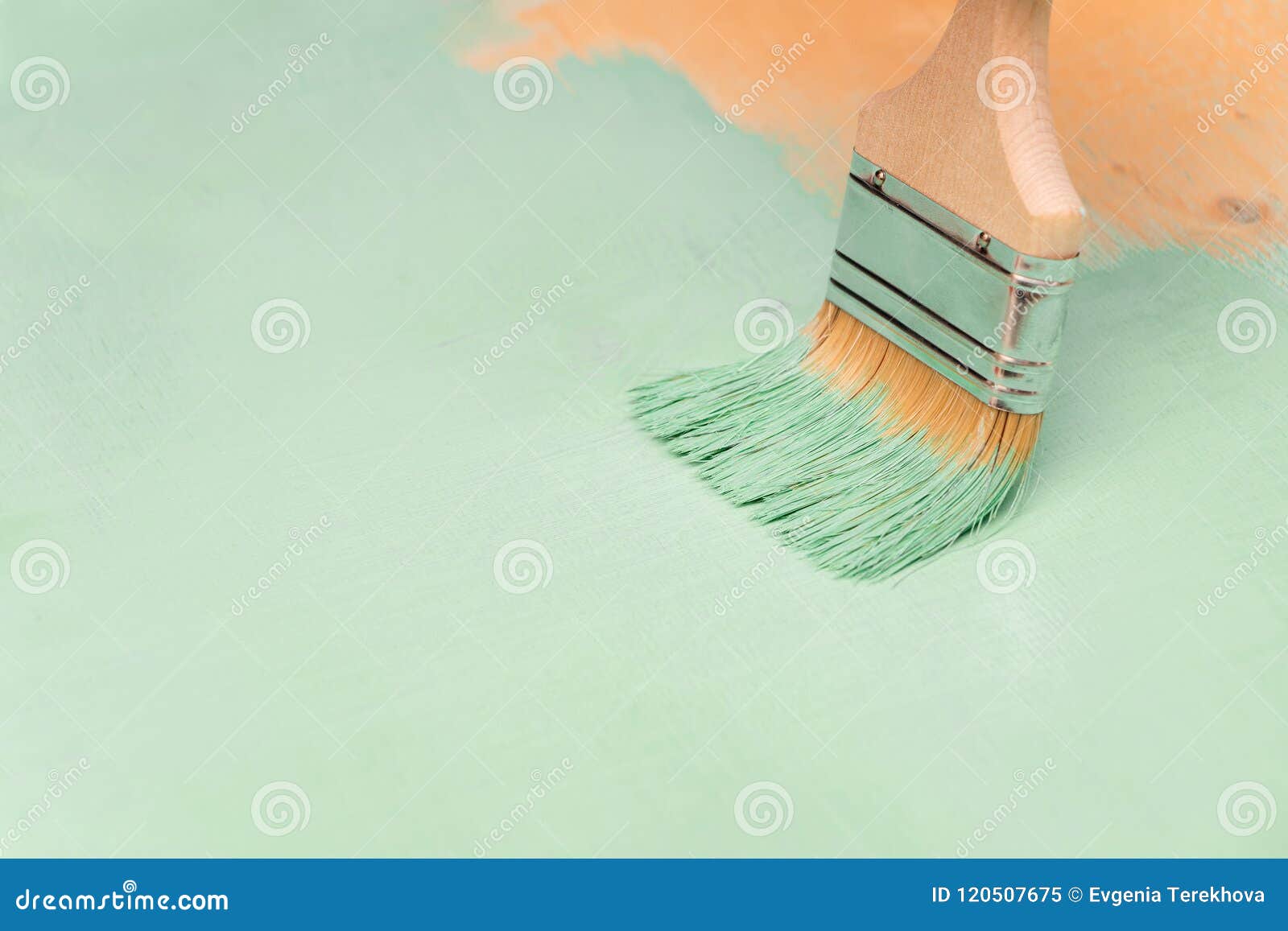 Staining Wood Surfaces with Green Paint Using a Paint Brush Stock Image