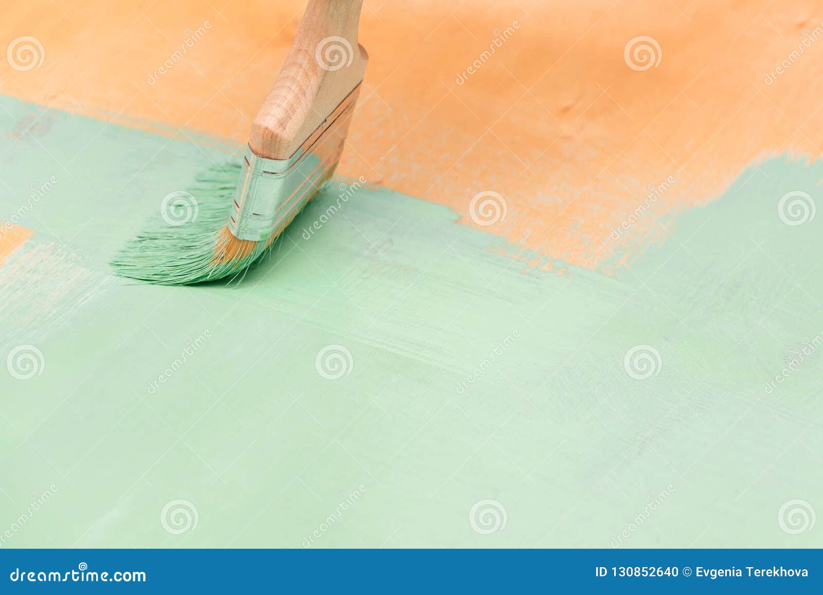 Staining Wood Surfaces With Green Paint Using A Paint Brush Royalty