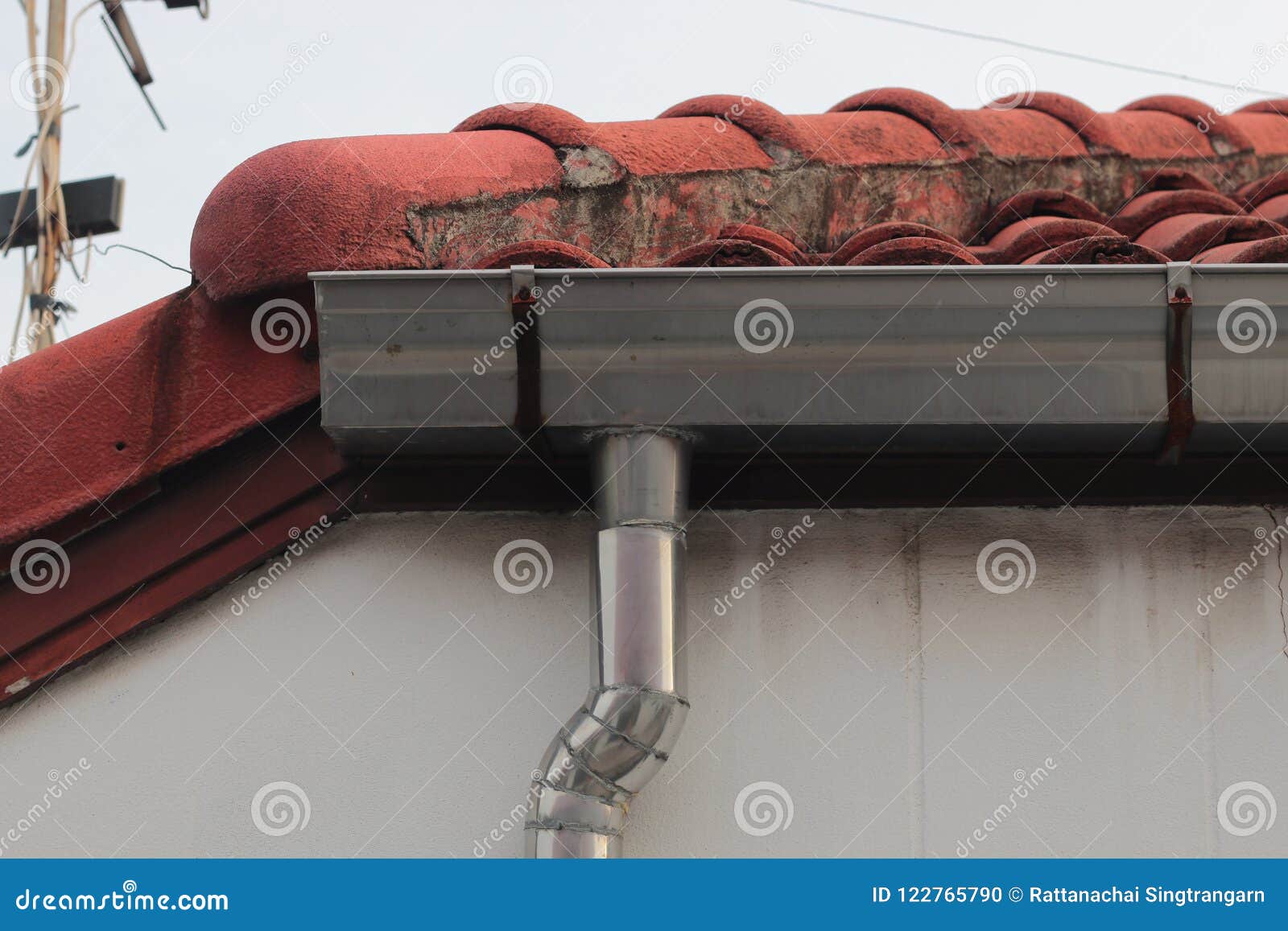 Stainless Steel Pipe Gutter at Corner Roof with Sky . Stock Photo