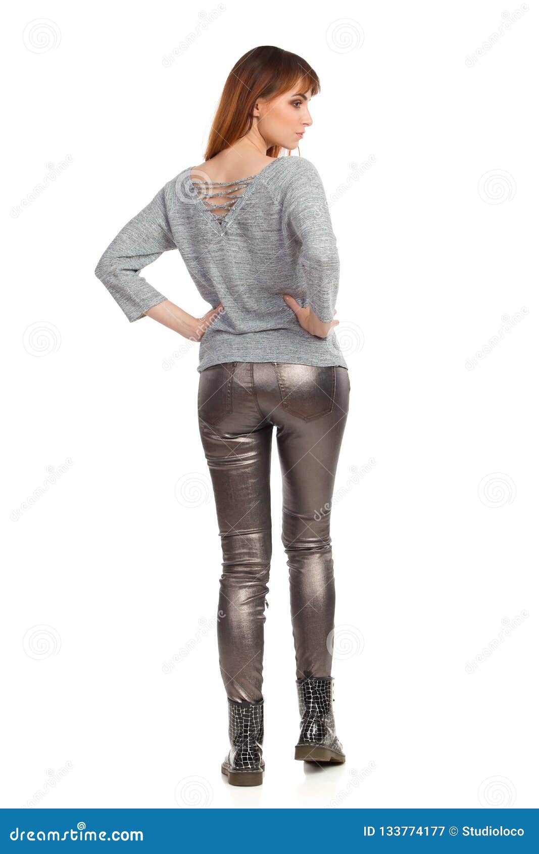 Standing Young Woman in Gray Blouse, Shiny Pants and Black Boots. Rear ...