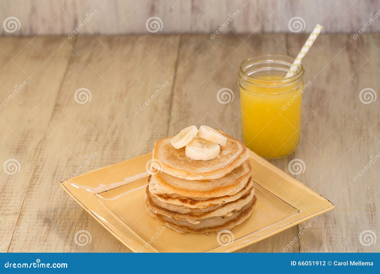 Stapel Pannekoeken met Bananen en Vers Jus d'orange. Een stapel smakelijke ontbijtpannekoeken met bananen en een glas vers gedrukt jus d'orange