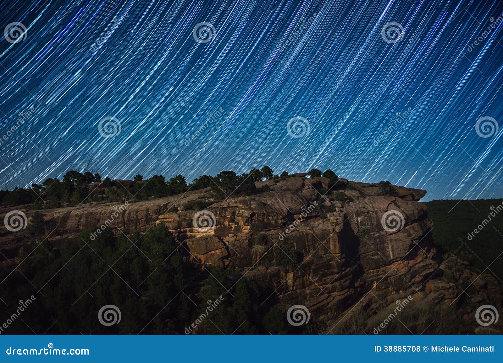 star trail above rock cliff