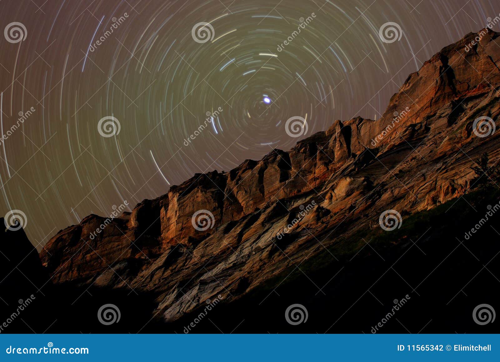 star trails around polaris above desert cliffs