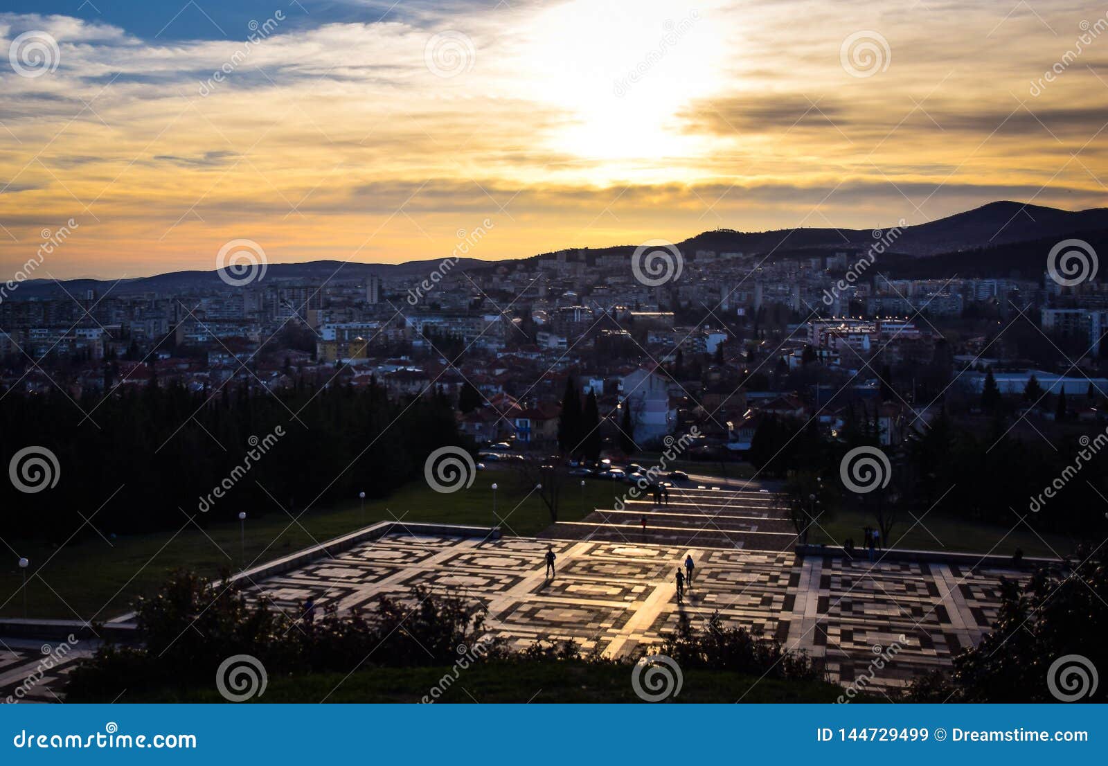 Stara Zagora, Bulgarien, barnsamaritflaggan, solnedgång över staden. Stara Zagora, Bulgarien, barnsamaritflaggan, solnedgången över staden, den tidiga våren, lördagkvällen, nMarch 28, 2019, 18 e.m., folk tycker om det varma solskenet av den börjande våren