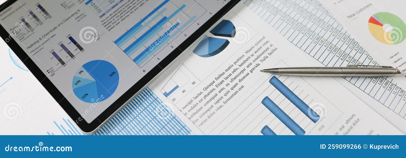 On Statistical Reports Lies a Tablet with Charts on the Screen Stock ...