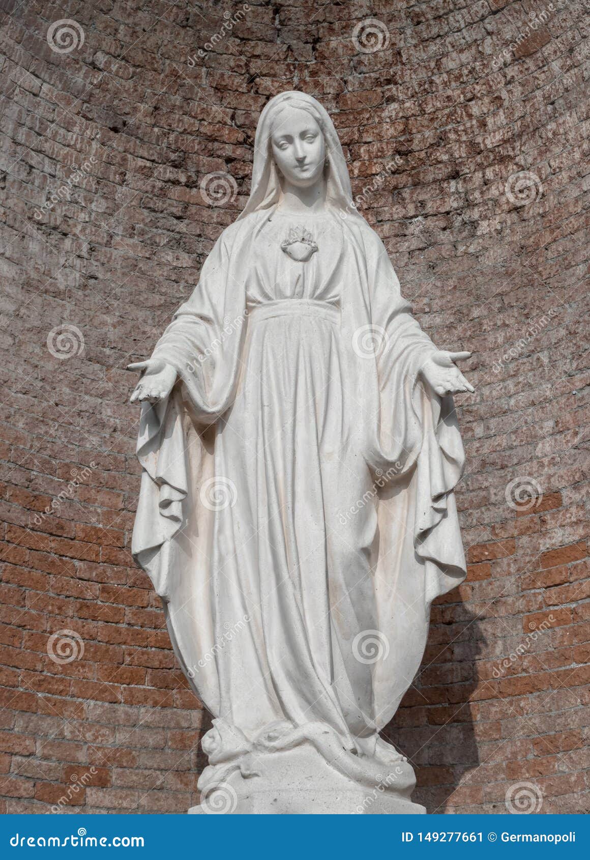 Statua w kamieniu maryja dziewica. Statue in stone of Virgin Mary. On background, red brick wall. Ideal for christmas and easter concepts and other