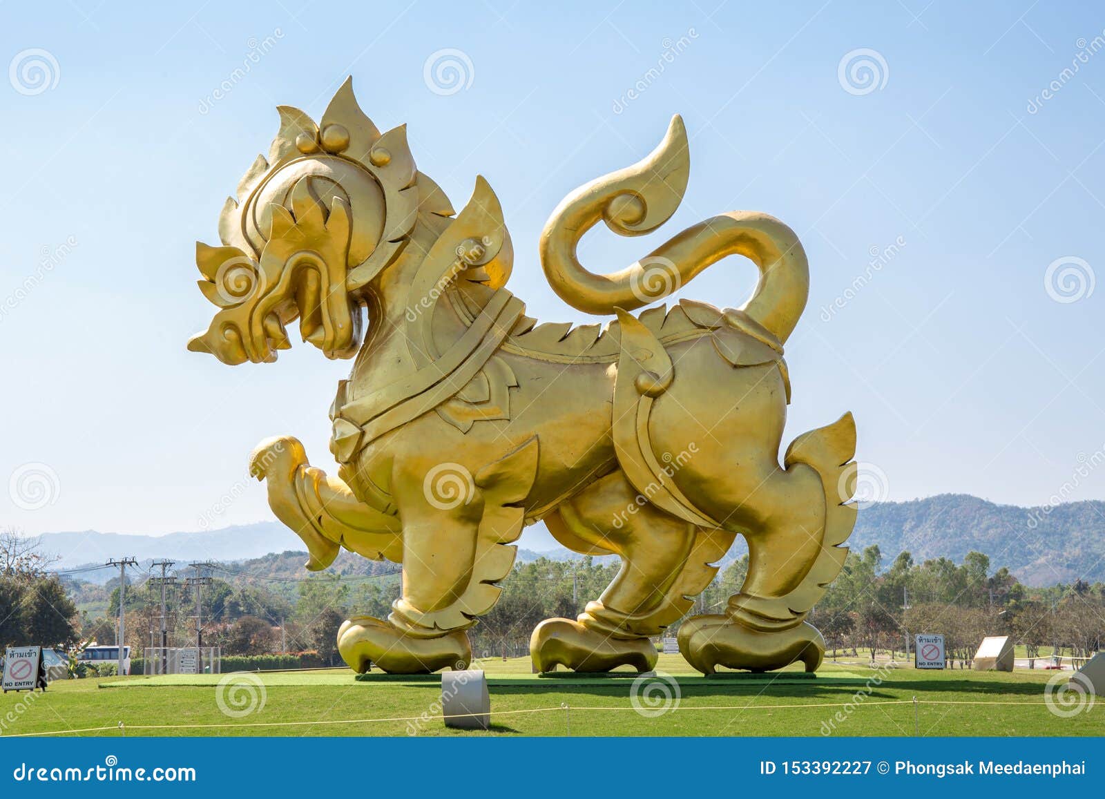 Statua złoty lew na polu z niebieskiego nieba tłem przy Singha parkiem Chiangrai Tajlandia,. Chiangrai, Tajlandia - Luty 25, 2017: Statua z?oty lew na polu z niebieskiego nieba t?em przy Singha parkiem Chiangrai Tajlandia,