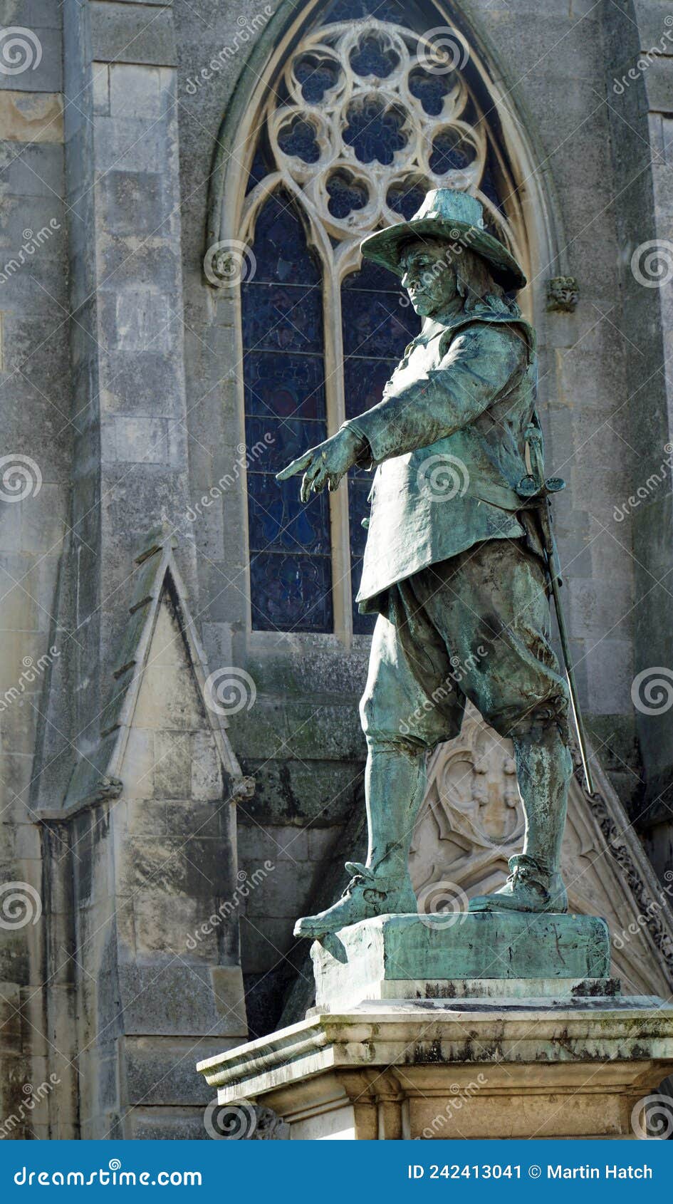 statue of oliver cromwell with church window in background