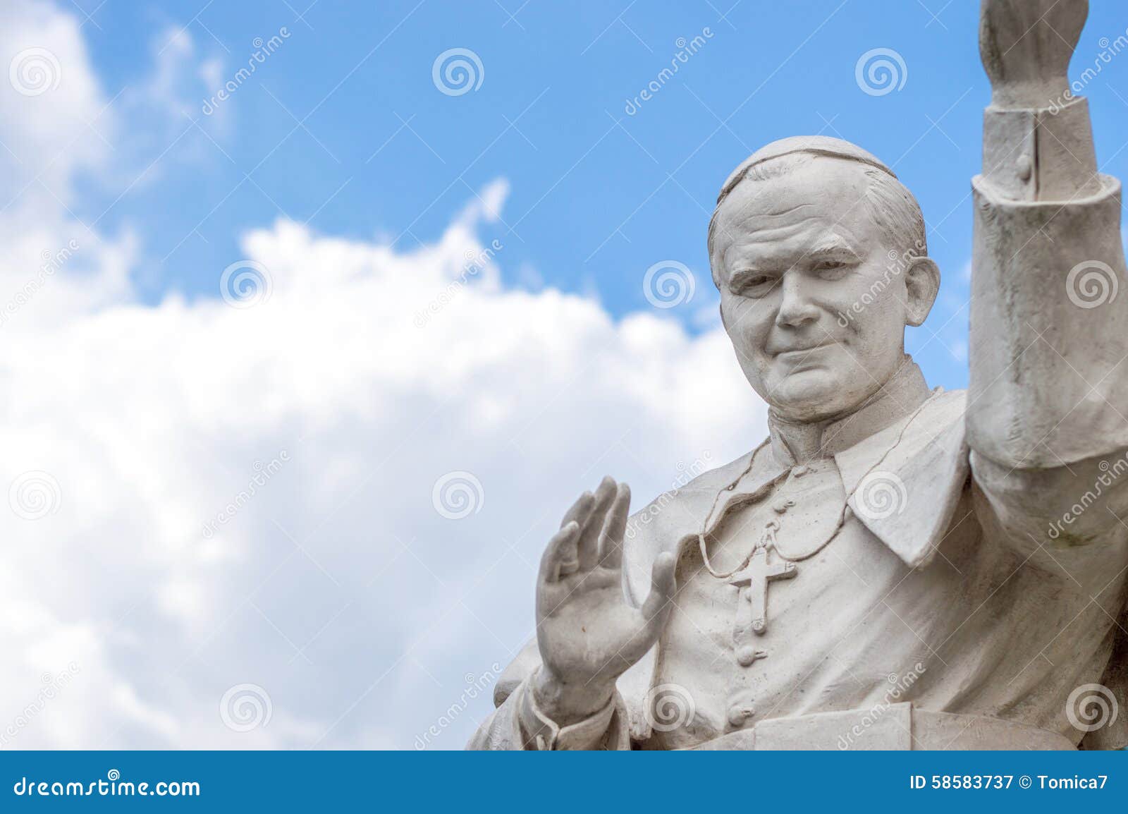 statue of pope john paul ii blessing people, with cloudy sky in
