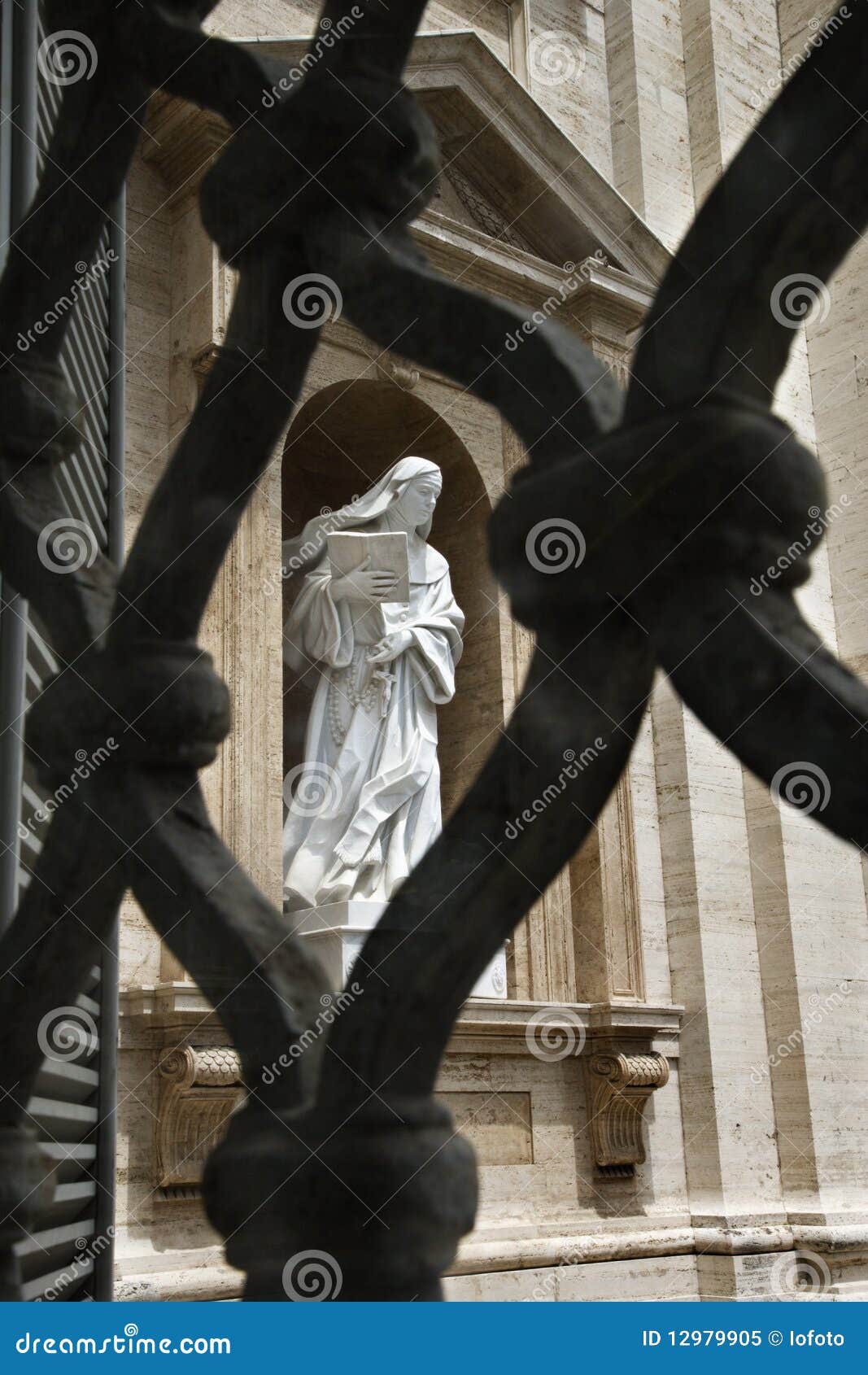 statue of saint teresa of avila viewed through fen