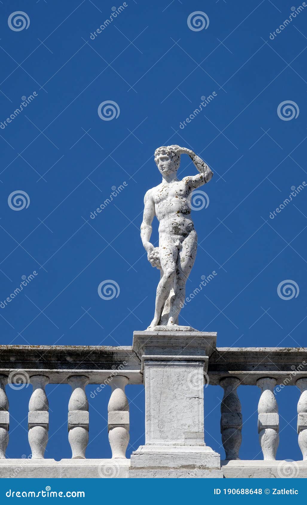 statue at the top of national library of st mark`s biblioteca marciana, venice, italy