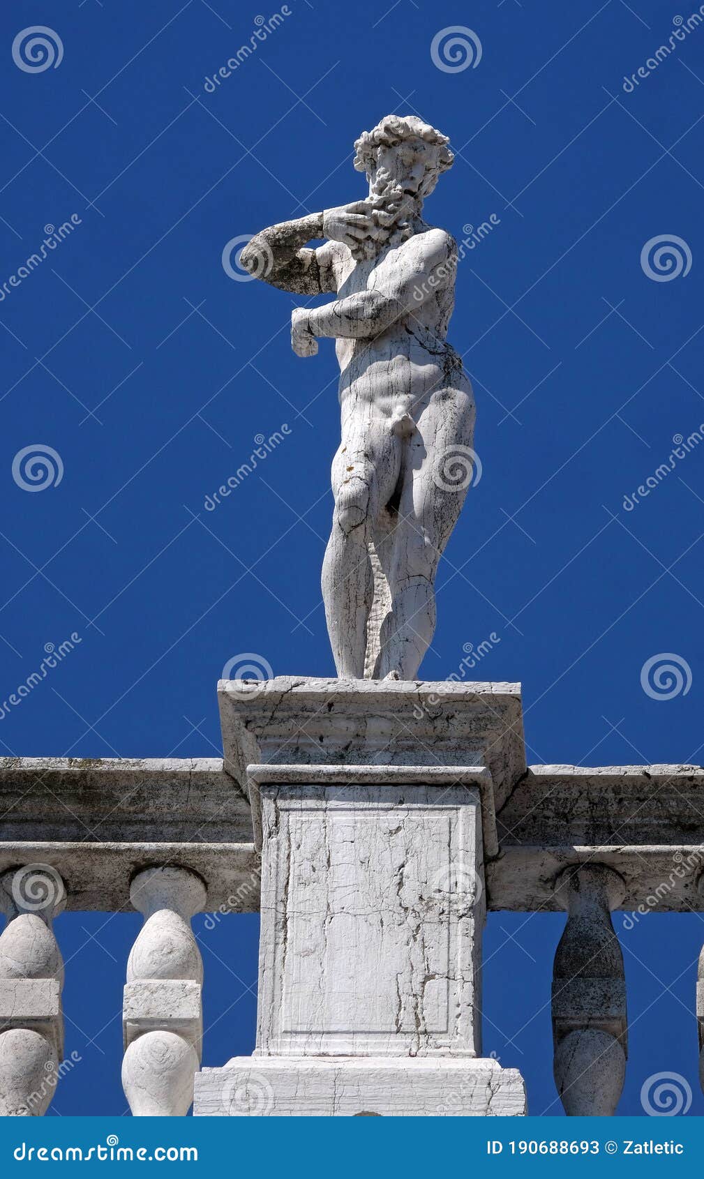 statue at the top of national library of st mark`s biblioteca marciana, venice, italy