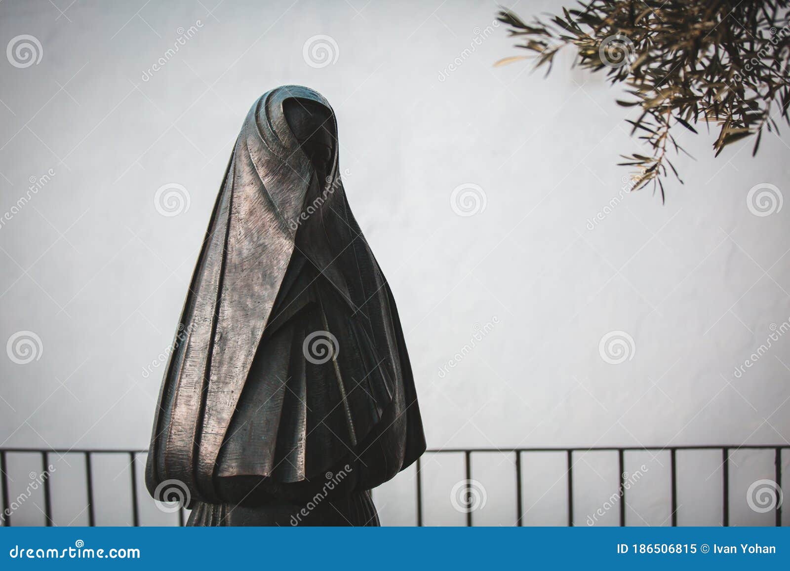 statue of a woman dressed in black cloak and head veil `la cobijada` from her back