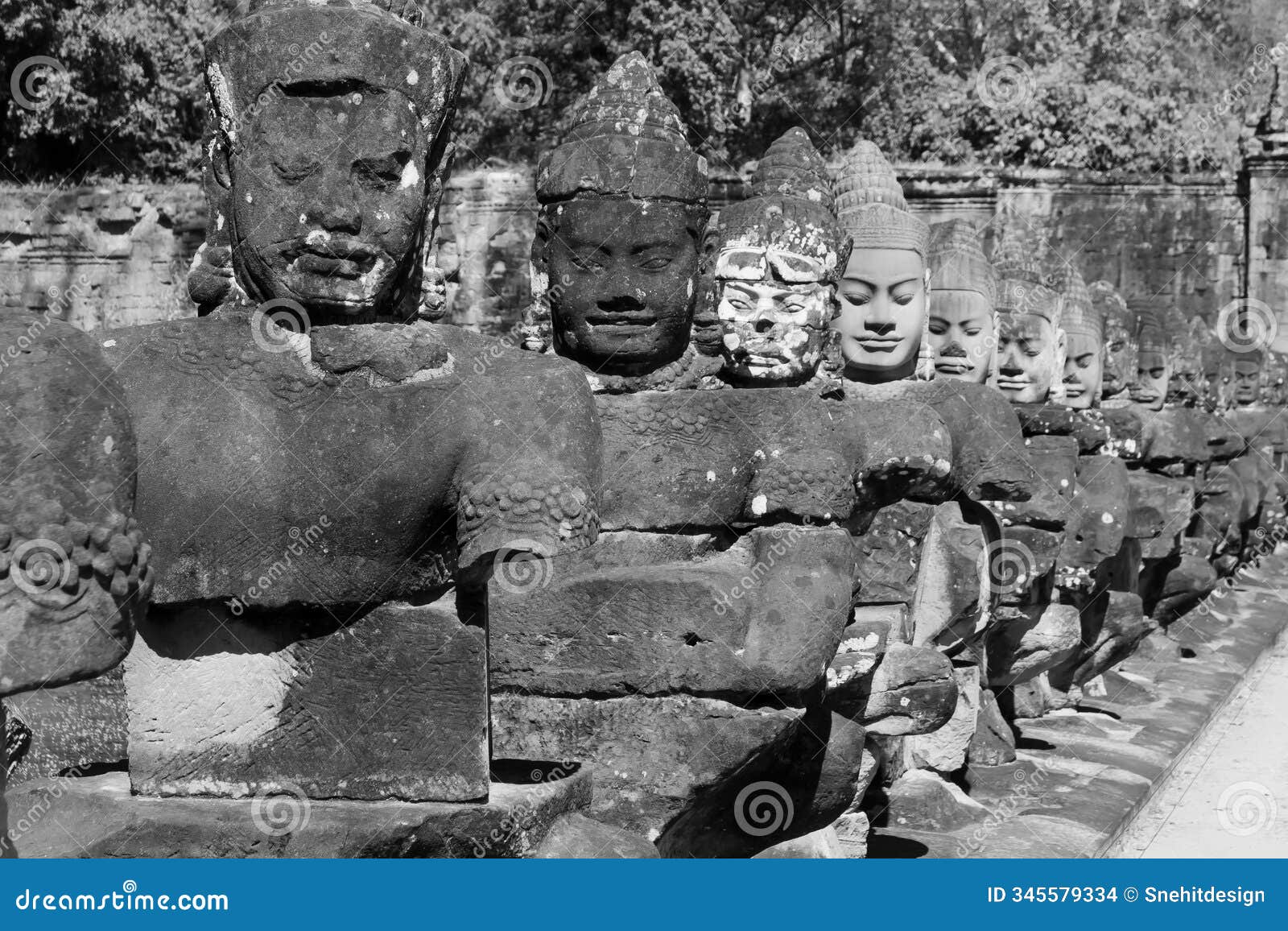 statues at tonle om south gate bridge in bayon temple complex, cambodia
