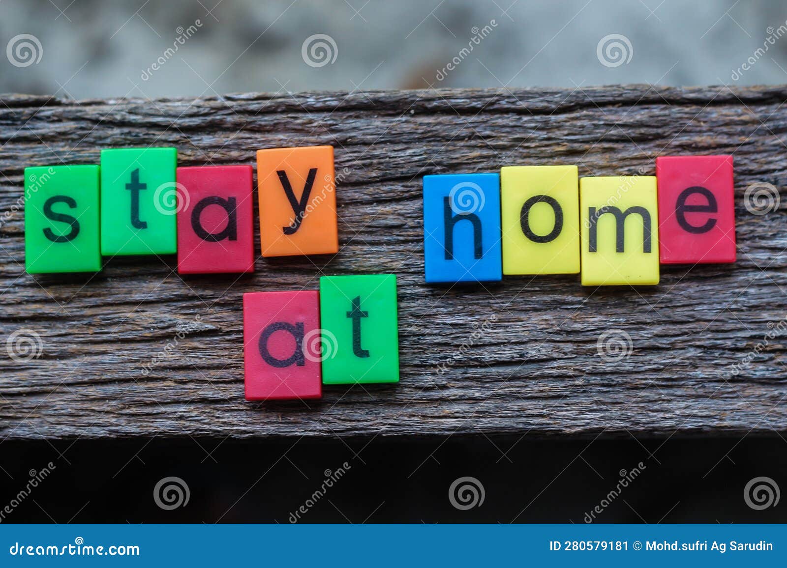 the stay home word written on black plastic block