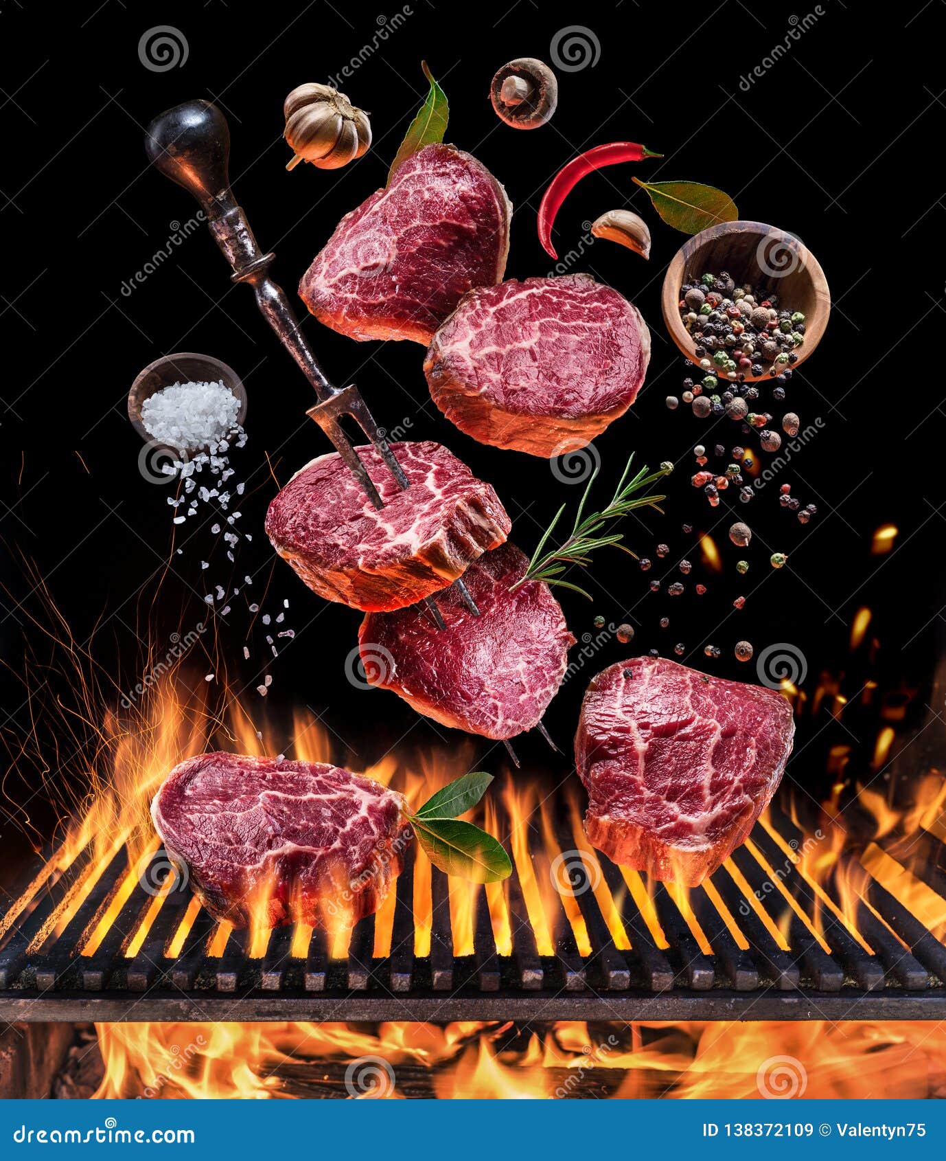 steak cooking. conceptual picture. steak with spices and cutlery under burning grill grate