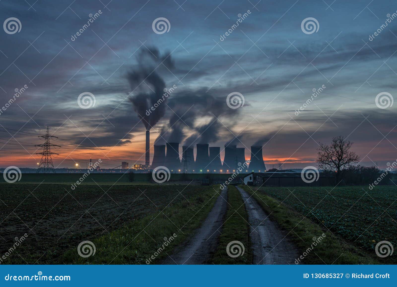 the steam rises from the cooling towers at sunset