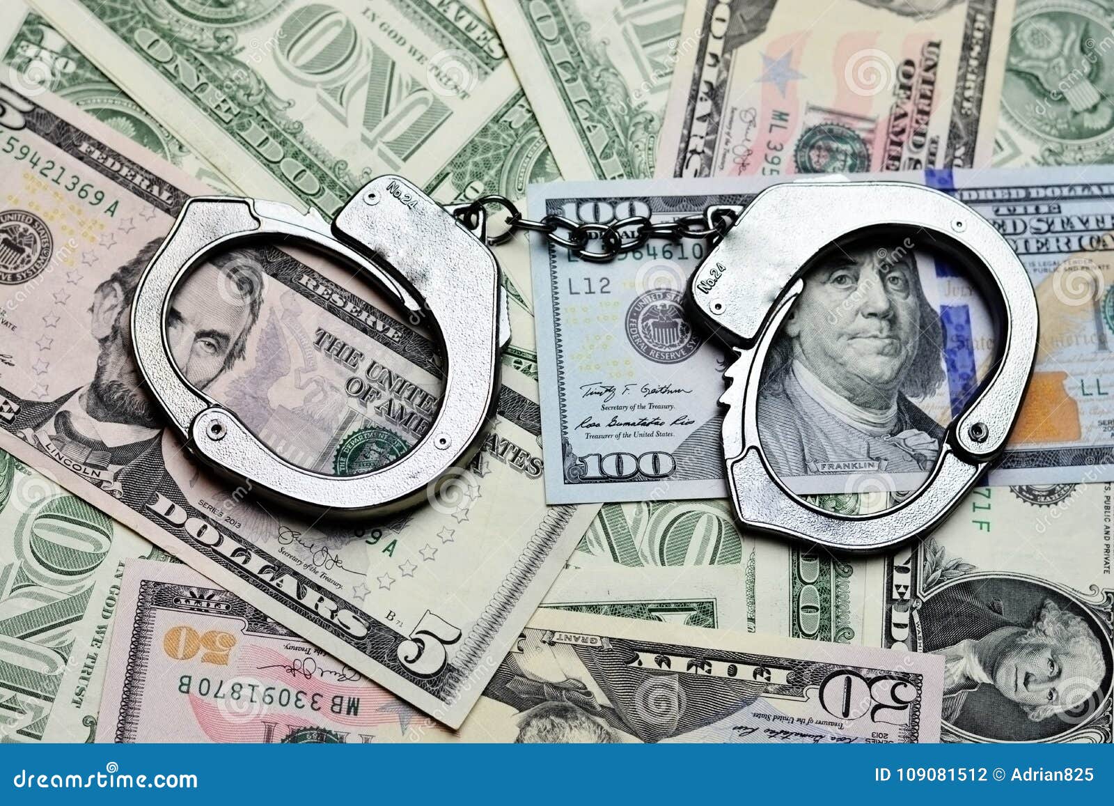 steel handcuffs above us dollar banknotes, tax evasion concept