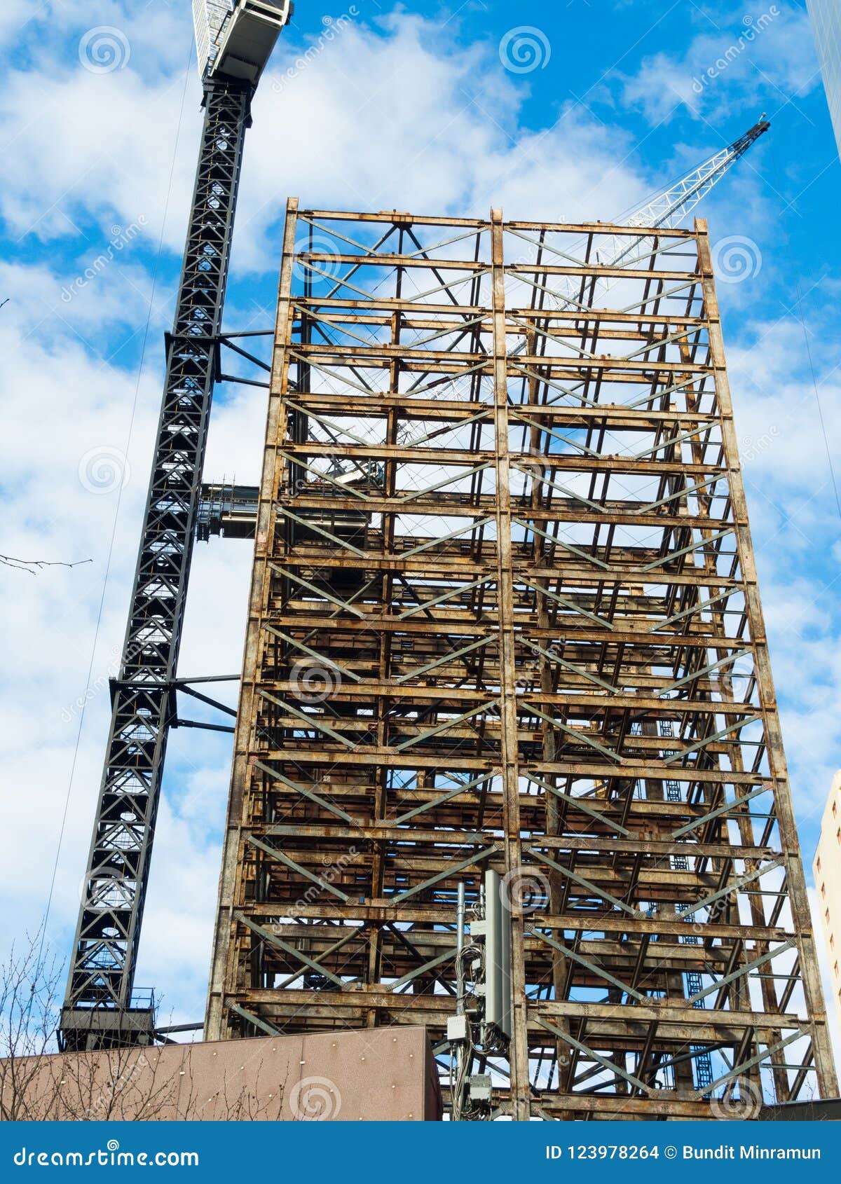 Steel Skeleton Tall Building Under Construction with Crane Tower. Stock