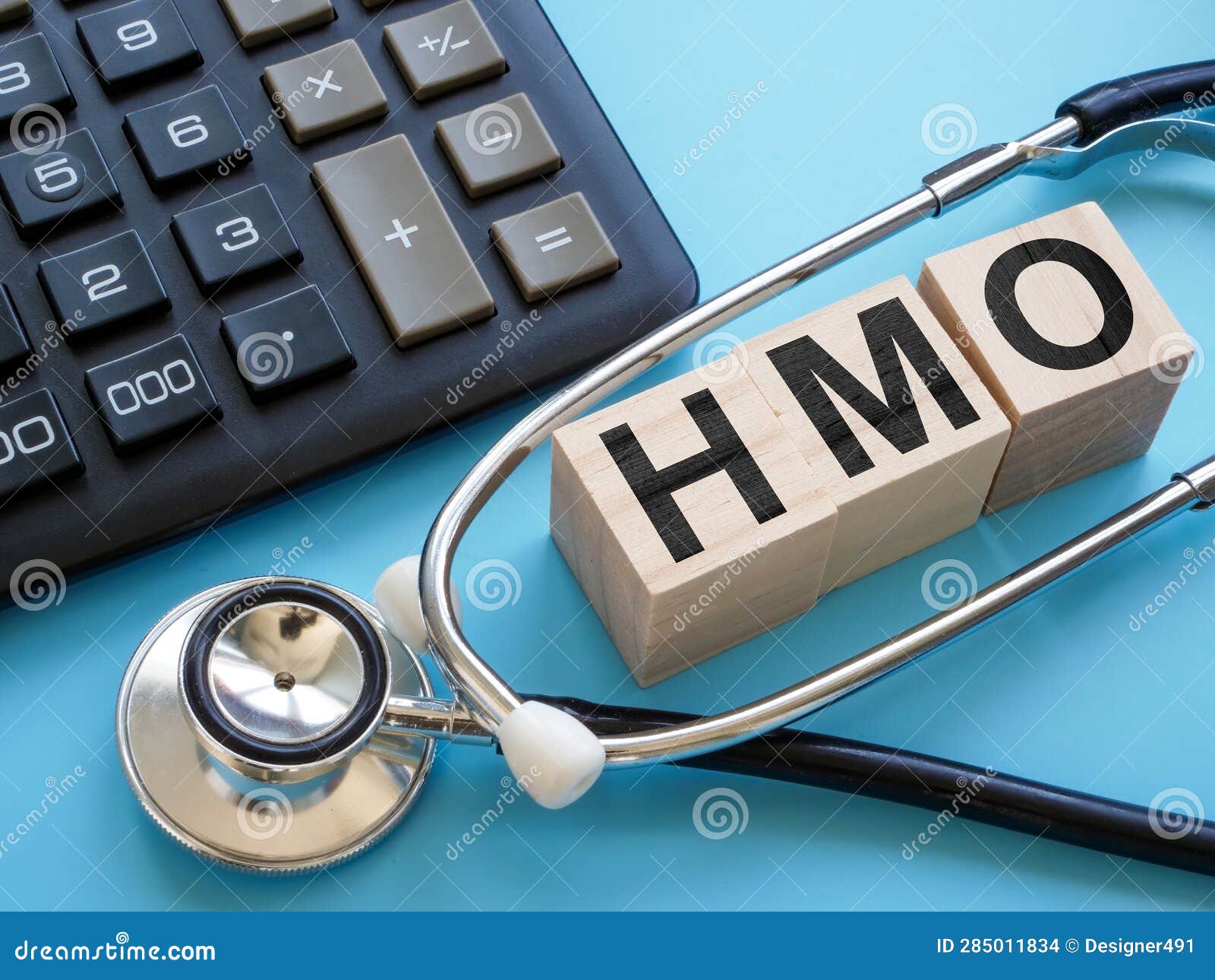 stethoscope and cubes with letters hmo health maintenance organization insurance.