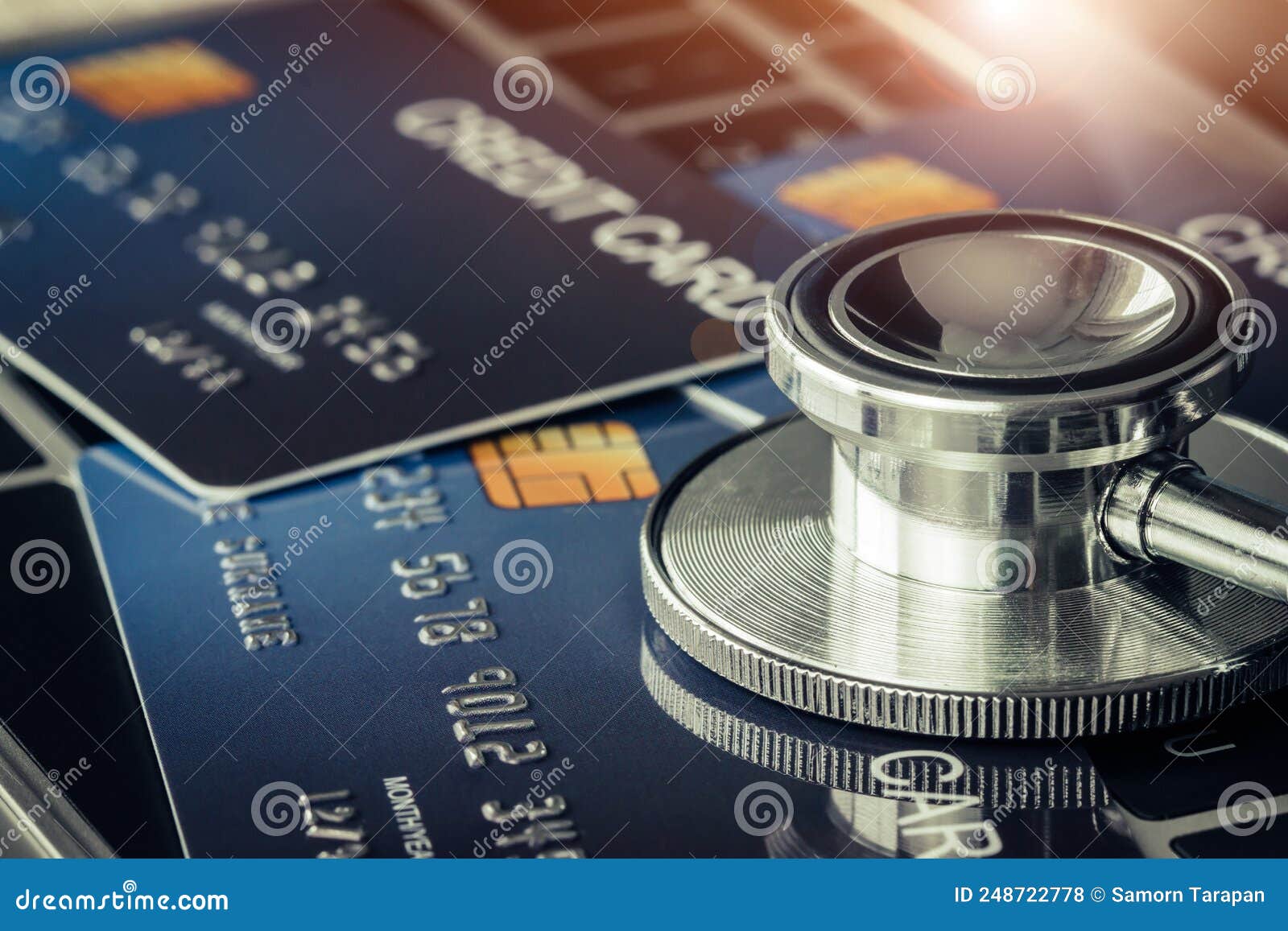 stethoscope on mock up credit card with number on card at computer in hostpital desk. health insurance and cost of medical care,