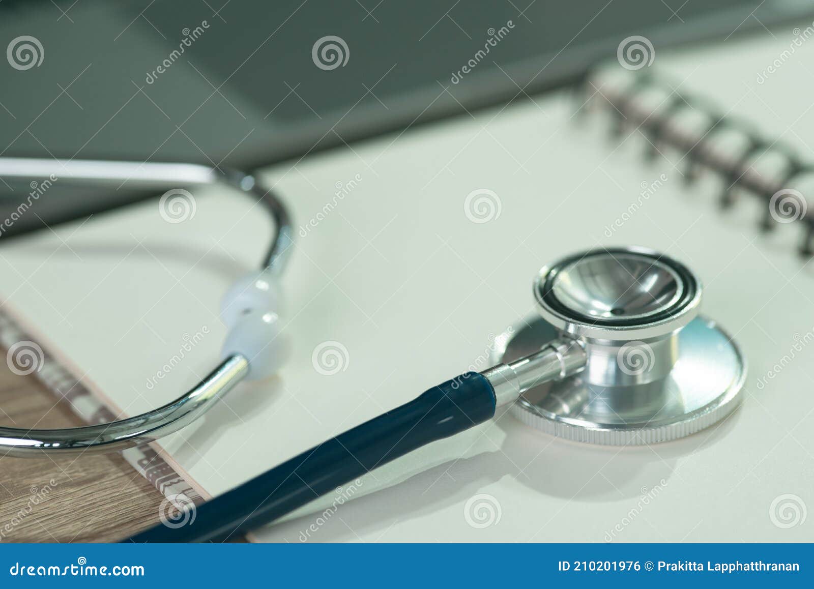 a stethoscope placed on a white notebook