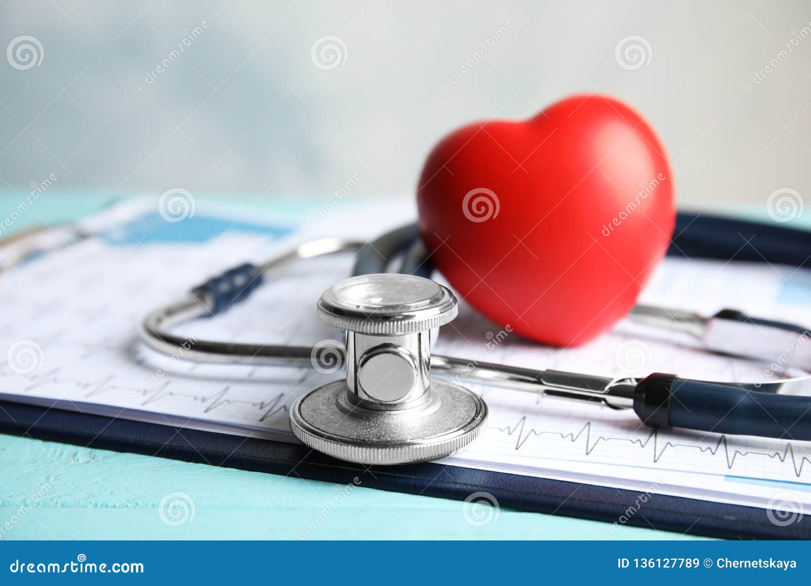 stethoscope, red heart and cardiogram on table. cardiology