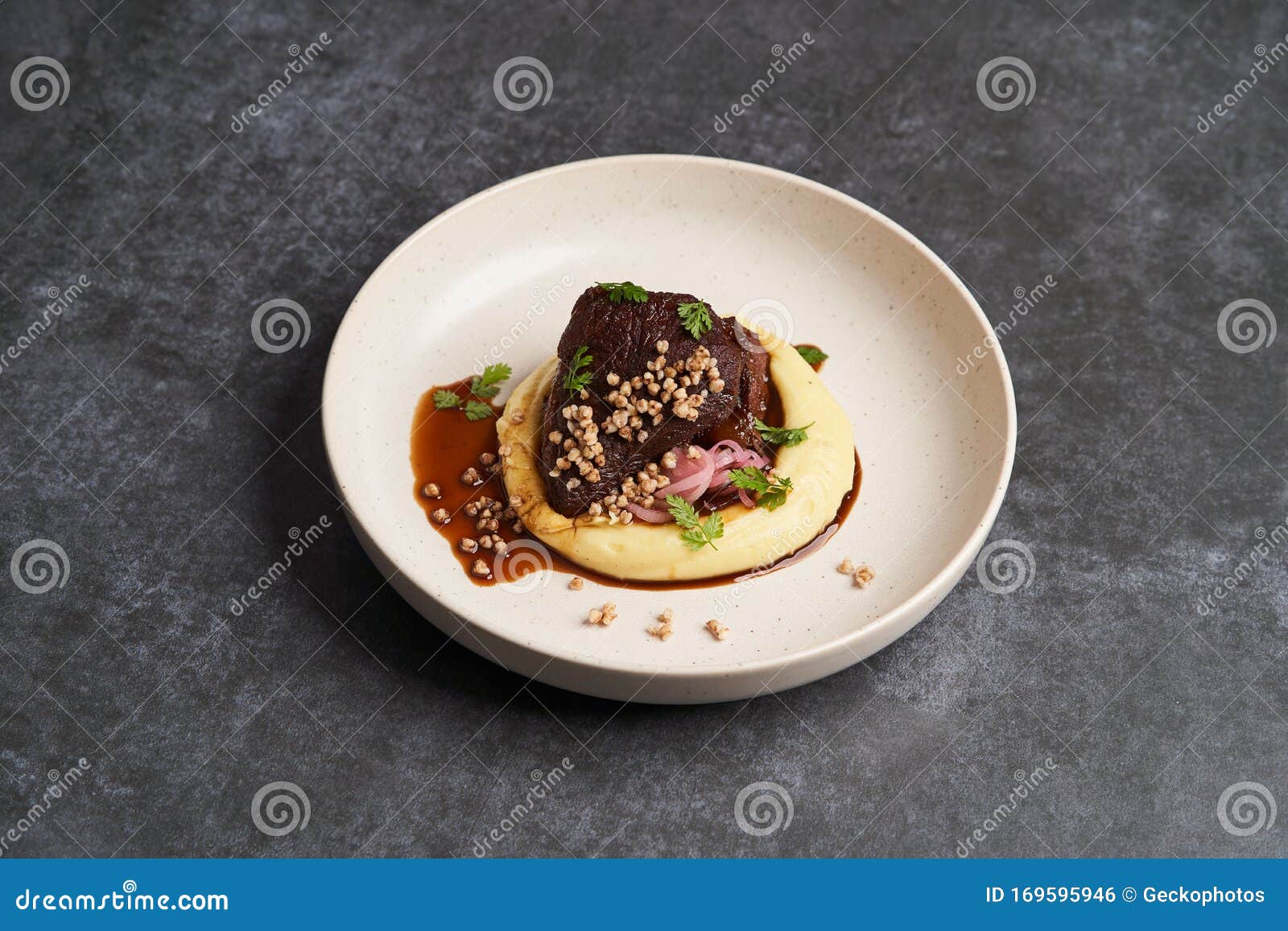 Stewed Veal Cheeks with Mashed Potatoes on a White Plate, Closeup
