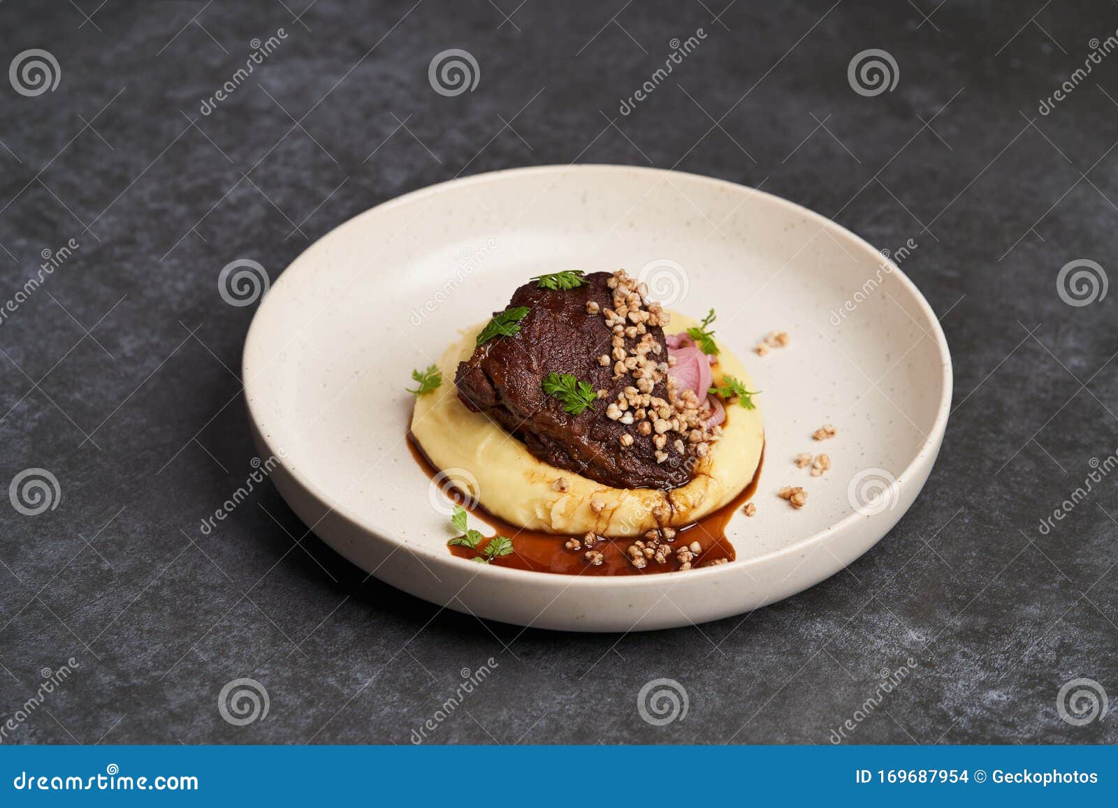 Stewed Veal Cheeks with Mashed Potatoes on a White Plate, Closeup