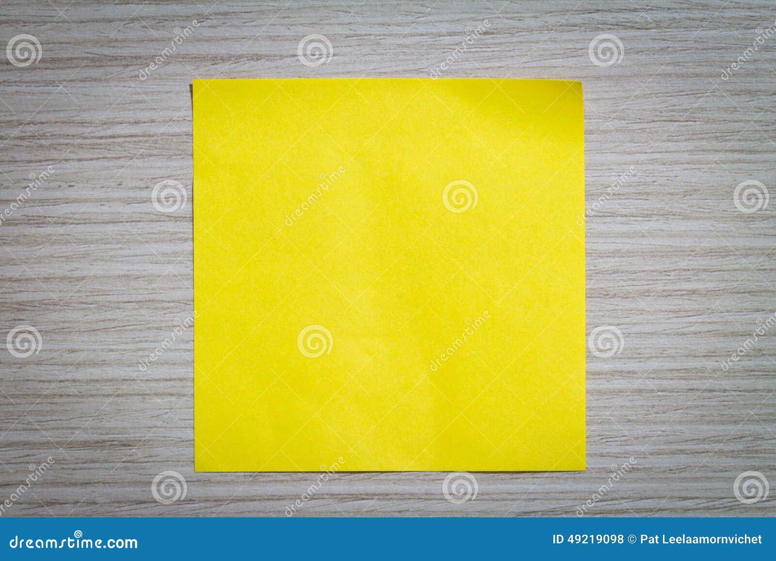 Yellow sticky note attach to a wooden wall