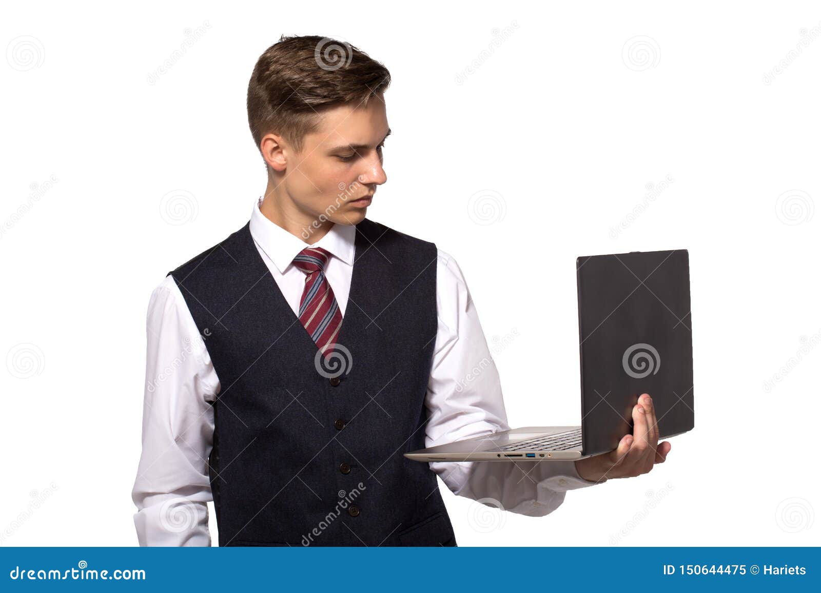 Stilig ung man som använder hans bärbar dator och ser den som står mot vit bakgrund