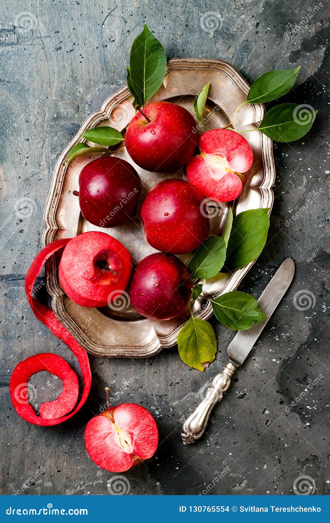 still life with apples on vintage plate over gray table, top view. fresh red apples baya marisa with leaves