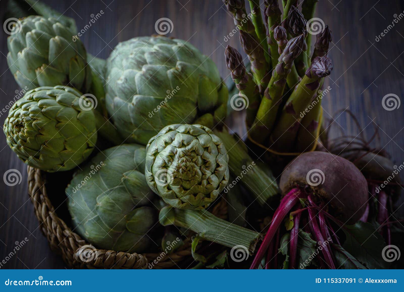 A Still Life of Artichokes and Asparagus and Young Beets on the Rustic Textured Background Stock