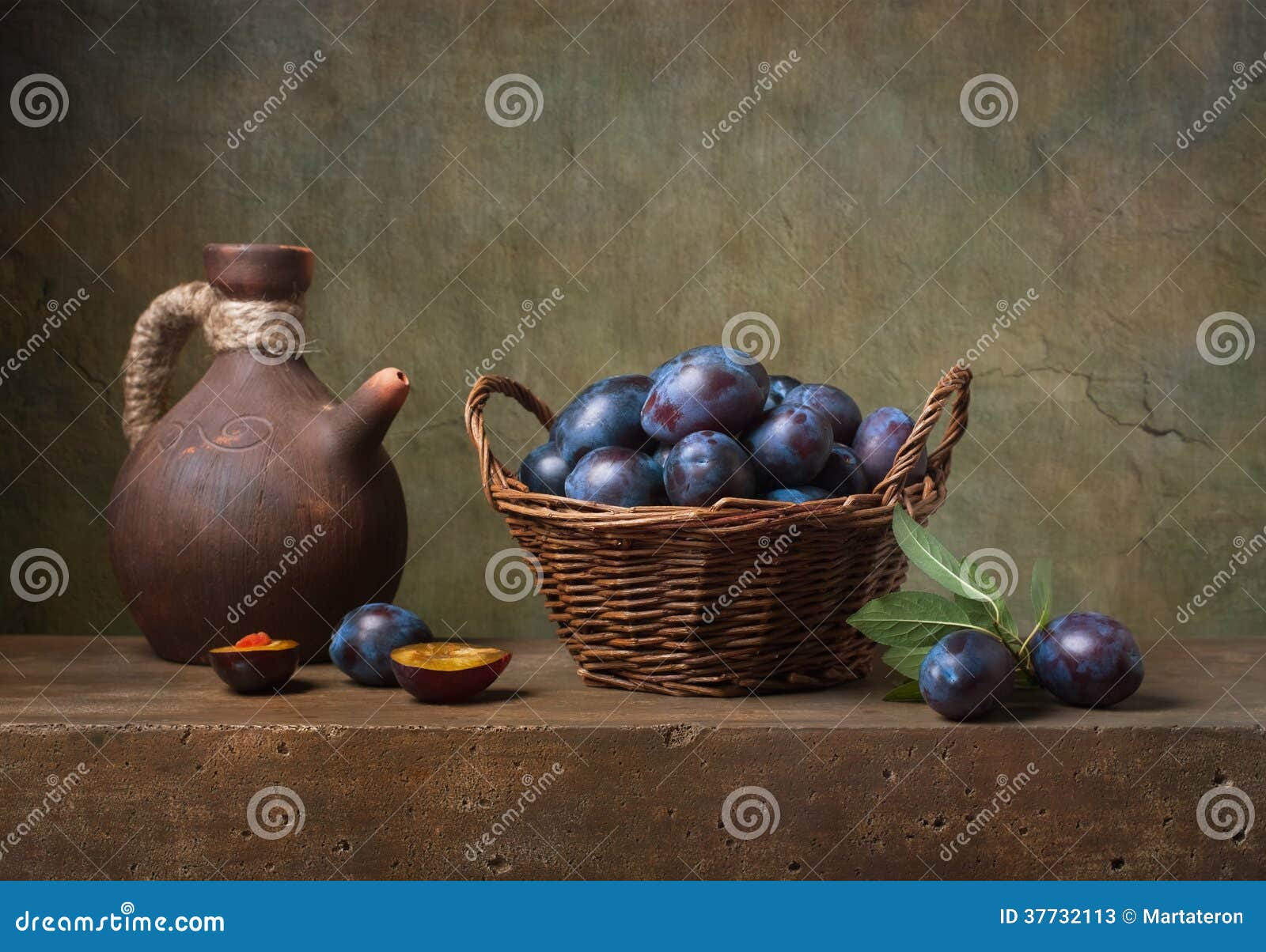 still life with black plums in a basket