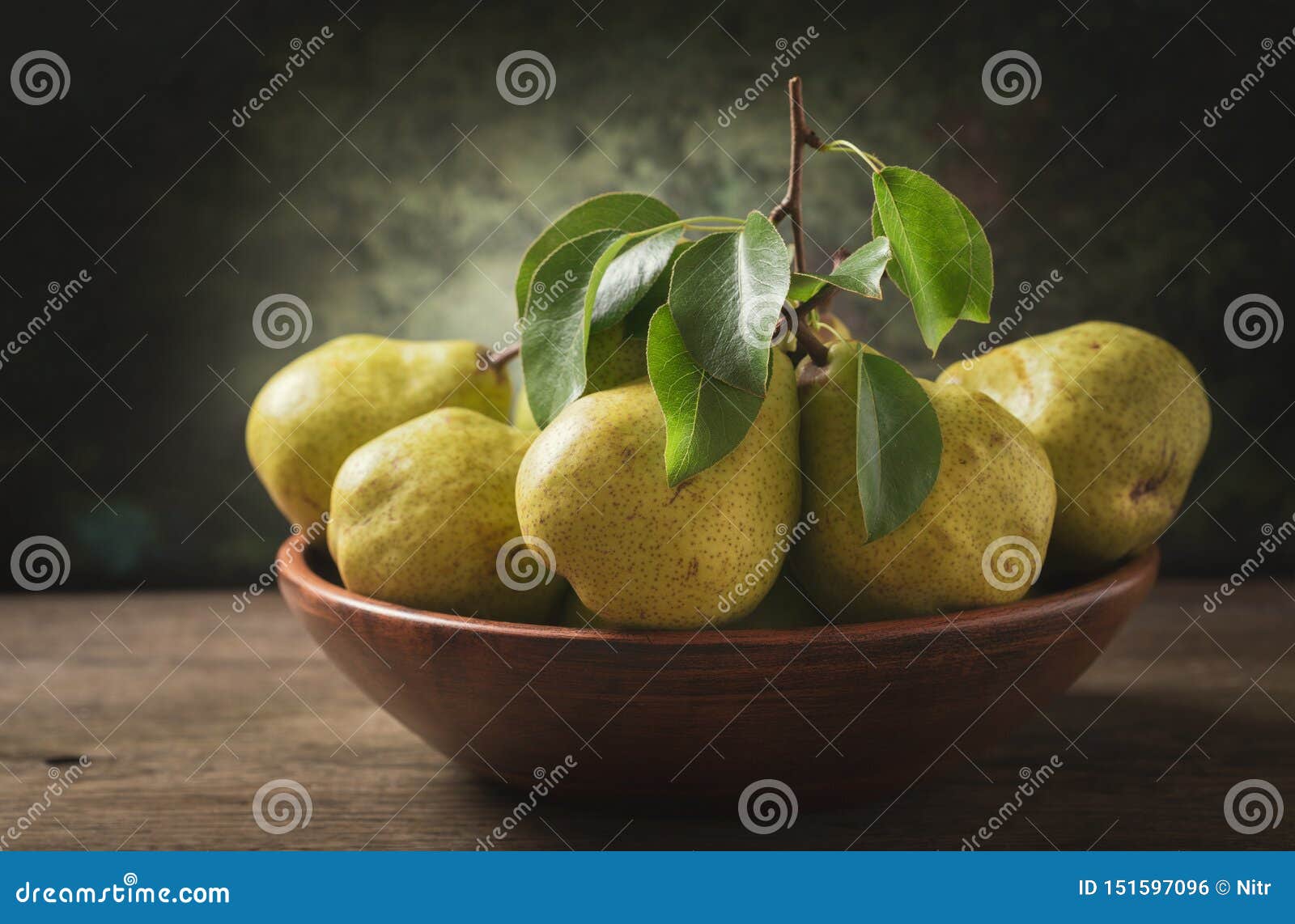 still life with fresh pears with leaves in a bowl