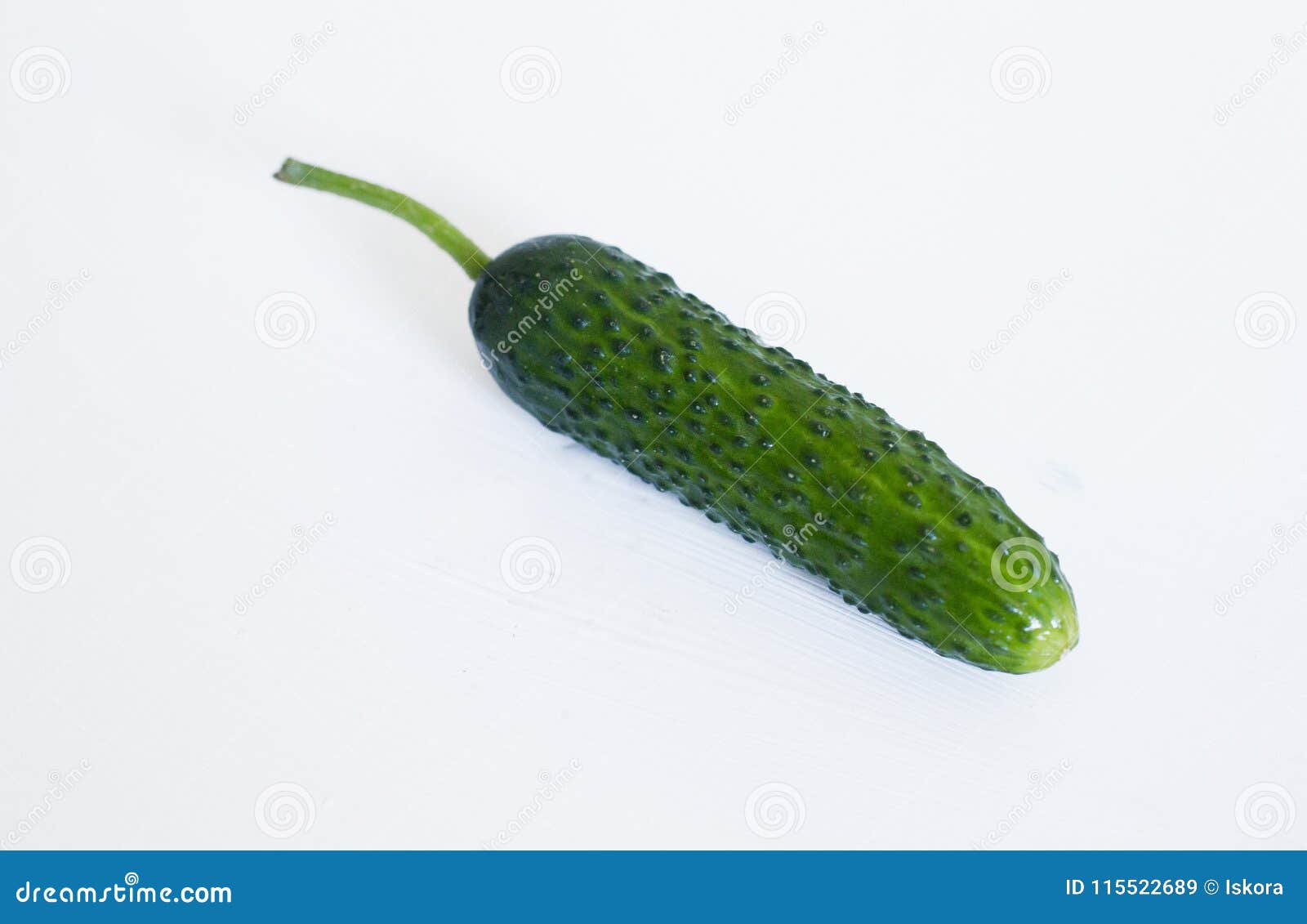 a whole green and bright cucumber on a white background.