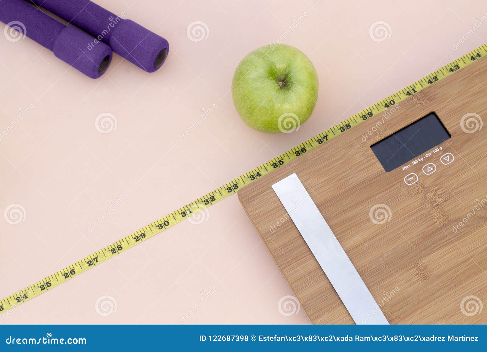 still life photography with a green apple, weight tape measure and a scale